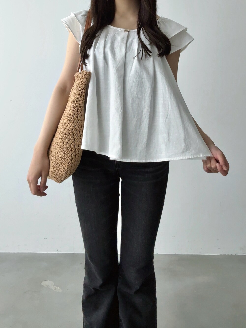 ホワイト系のシャツ/ブラウス、ブラウン系のトートバッグ、ブラック系のデニムパンツを着用したレディースの夏コーディネートの3枚目の写真