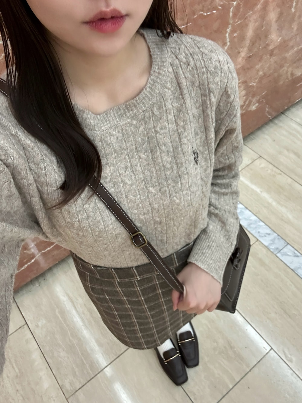 ベージュ系のニット/セーター、ブラウン系のショルダーバッグ、ブラウン系のスカートを着用したレディースの秋コーディネートの4枚目の写真