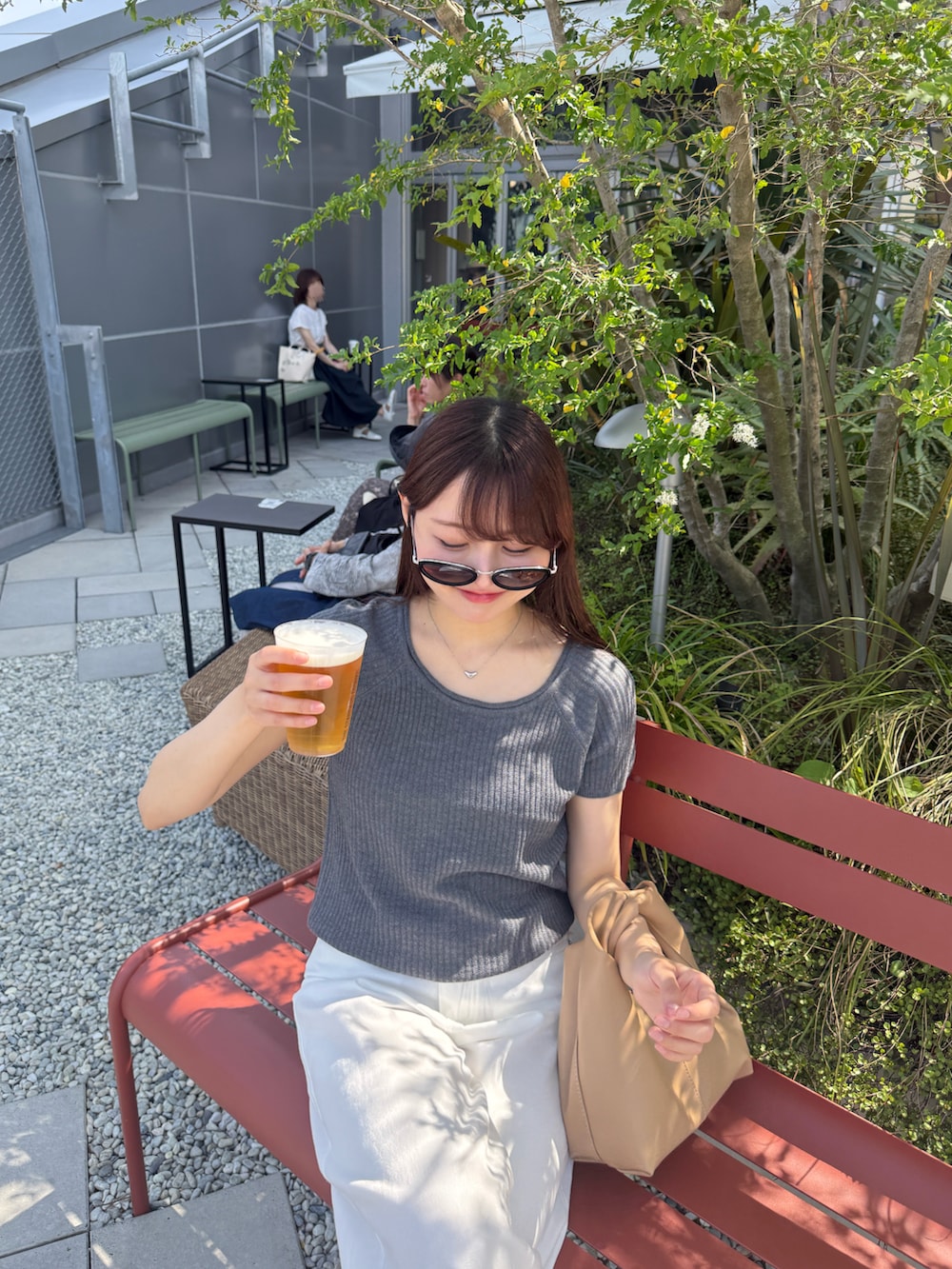 ホワイト系のデニムパンツ、ベージュ系のシューズ小物/雑貨、ブラック系のサンダルを着用したレディースの夏コーディネートの3枚目の写真