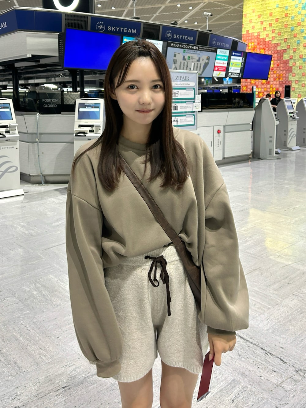 ブラウン系のスウェット、ホワイト系のその他パンツ、イエロー系のブーツを着用したレディースの秋コーディネートの3枚目の写真