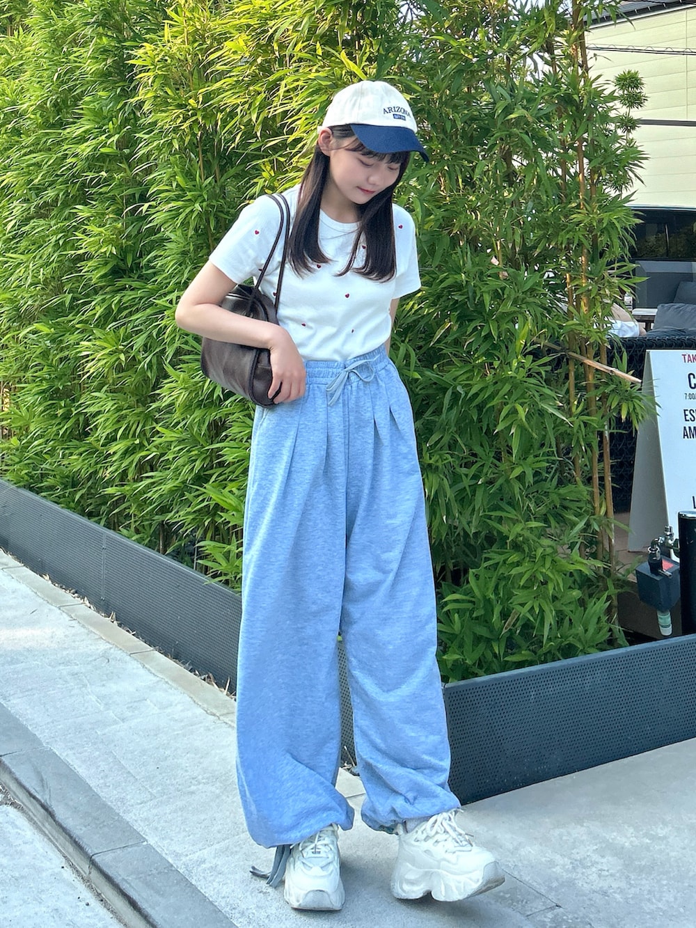 ホワイト系のTシャツ/カットソー、グレー系のスウェットパンツ、ホワイト系のスニーカーを着用したレディースの秋コーディネートの2枚目の写真