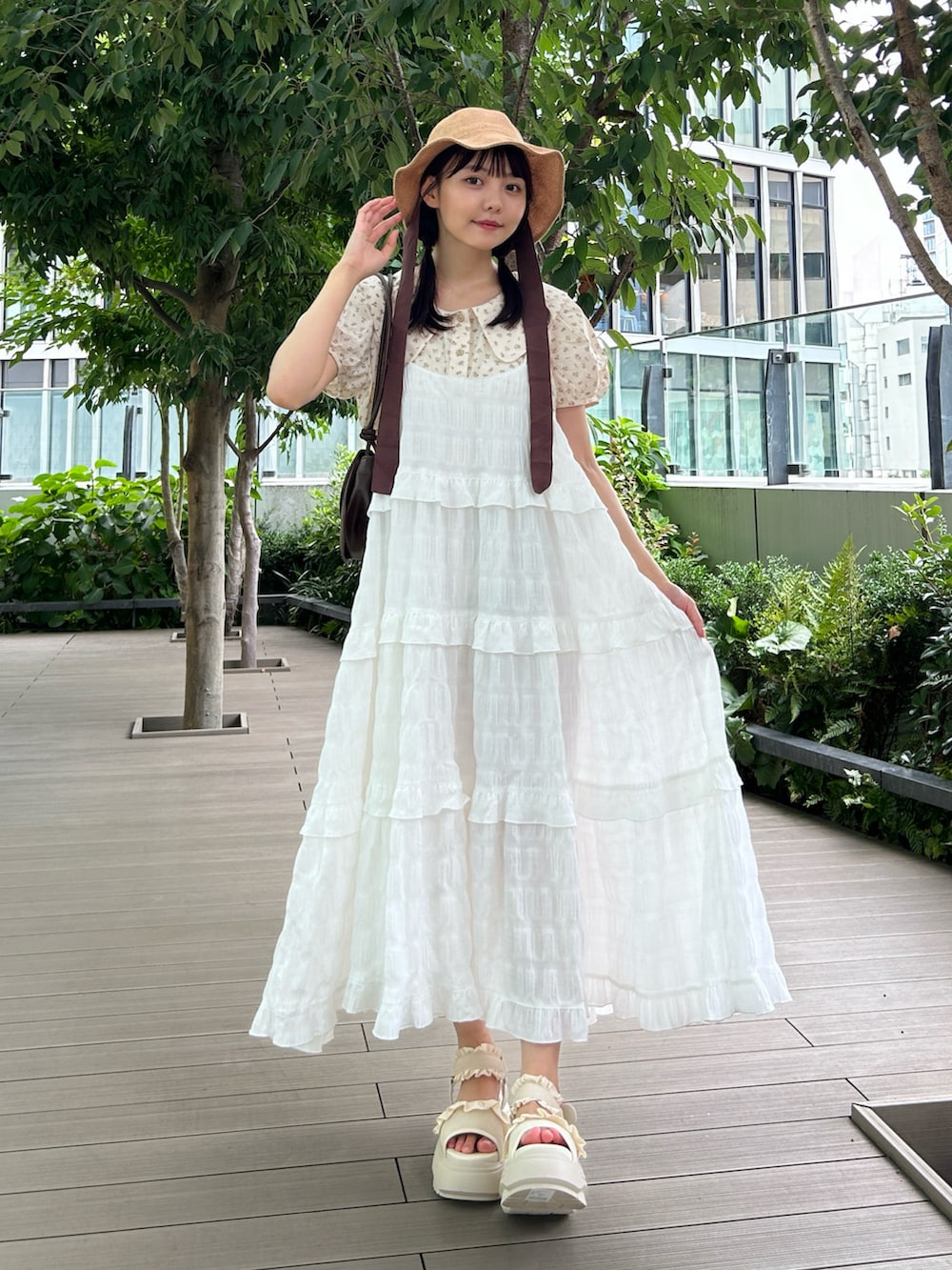 ホワイト系のワンピース、ベージュ系のシャツ/ブラウス、ホワイト系のサンダルを着用したレディースの夏コーディネートの2枚目の写真
