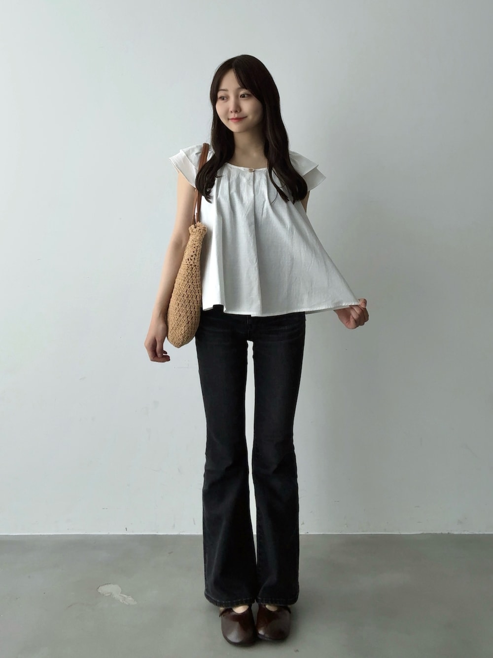 ホワイト系のシャツ/ブラウス、ブラウン系のトートバッグ、ブラック系のデニムパンツを着用したレディースの夏コーディネートの2枚目の写真