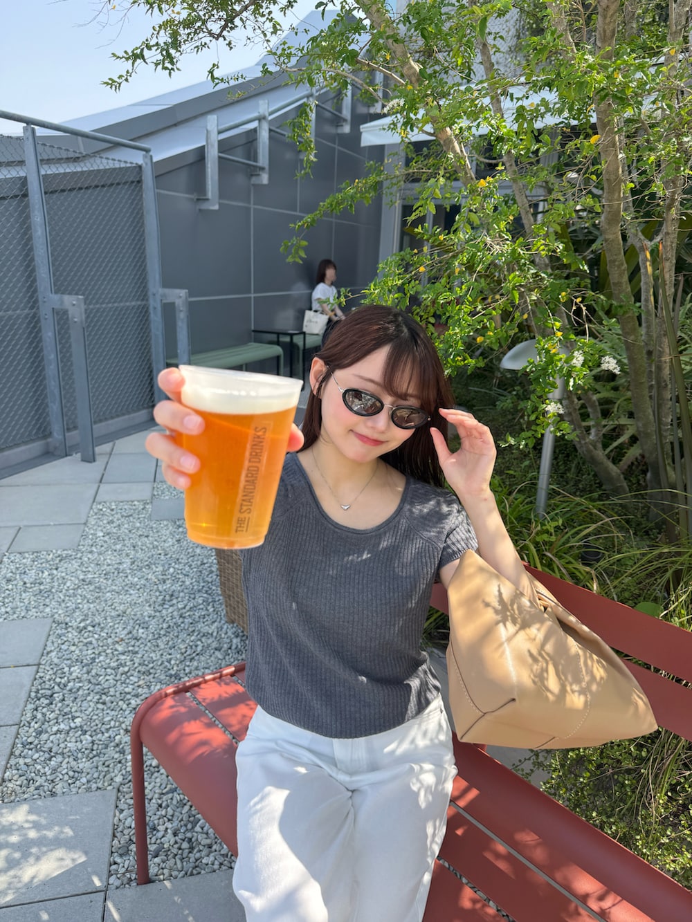 ホワイト系のデニムパンツ、ベージュ系のシューズ小物/雑貨、ブラック系のサンダルを着用したレディースの夏コーディネートの4枚目の写真