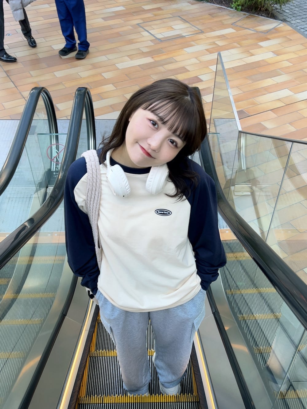 ベージュ系のTシャツ/カットソー、ベージュ系のトートバッグ、ホワイト系のスニーカーを着用したレディースの春コーディネートの5枚目の写真