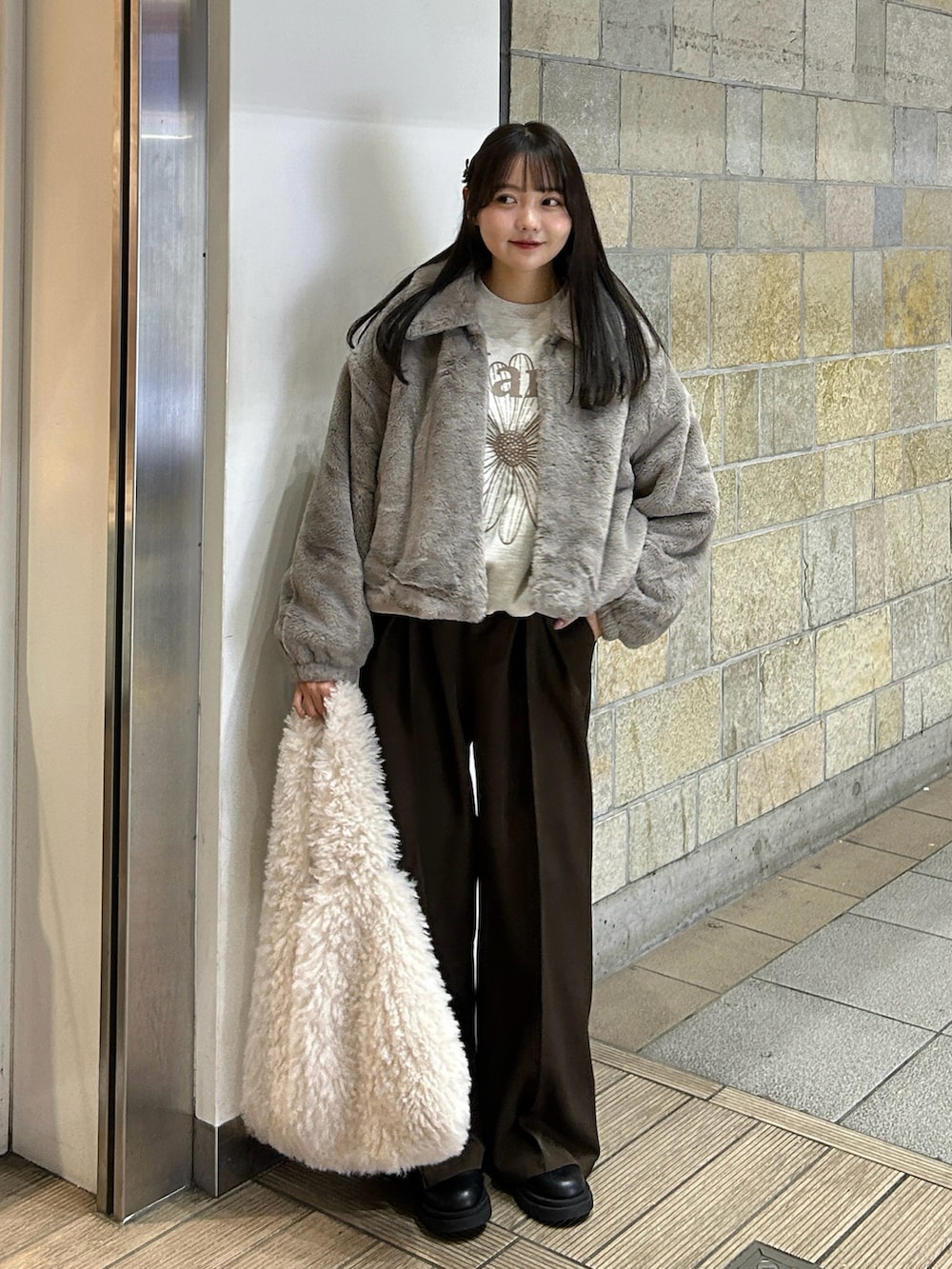 ベージュ系のその他アウター、ブラウン系のスラックス、ブラック系のブーツを着用したレディースの冬コーディネートの2枚目の写真