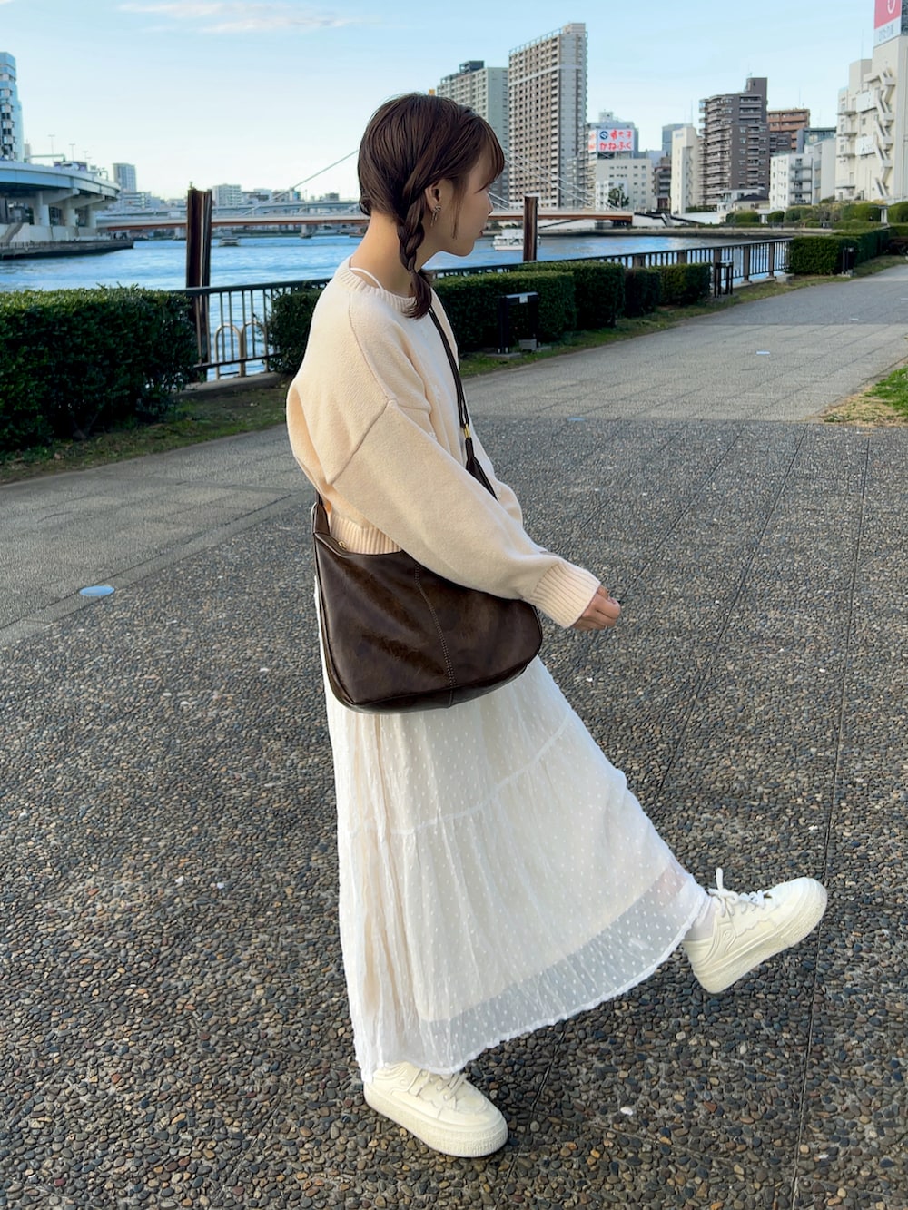 ピンク系のニット/セーター、ブラウン系のショルダーバッグ、ホワイト系のスカートを着用したレディースの冬コーディネートの3枚目の写真