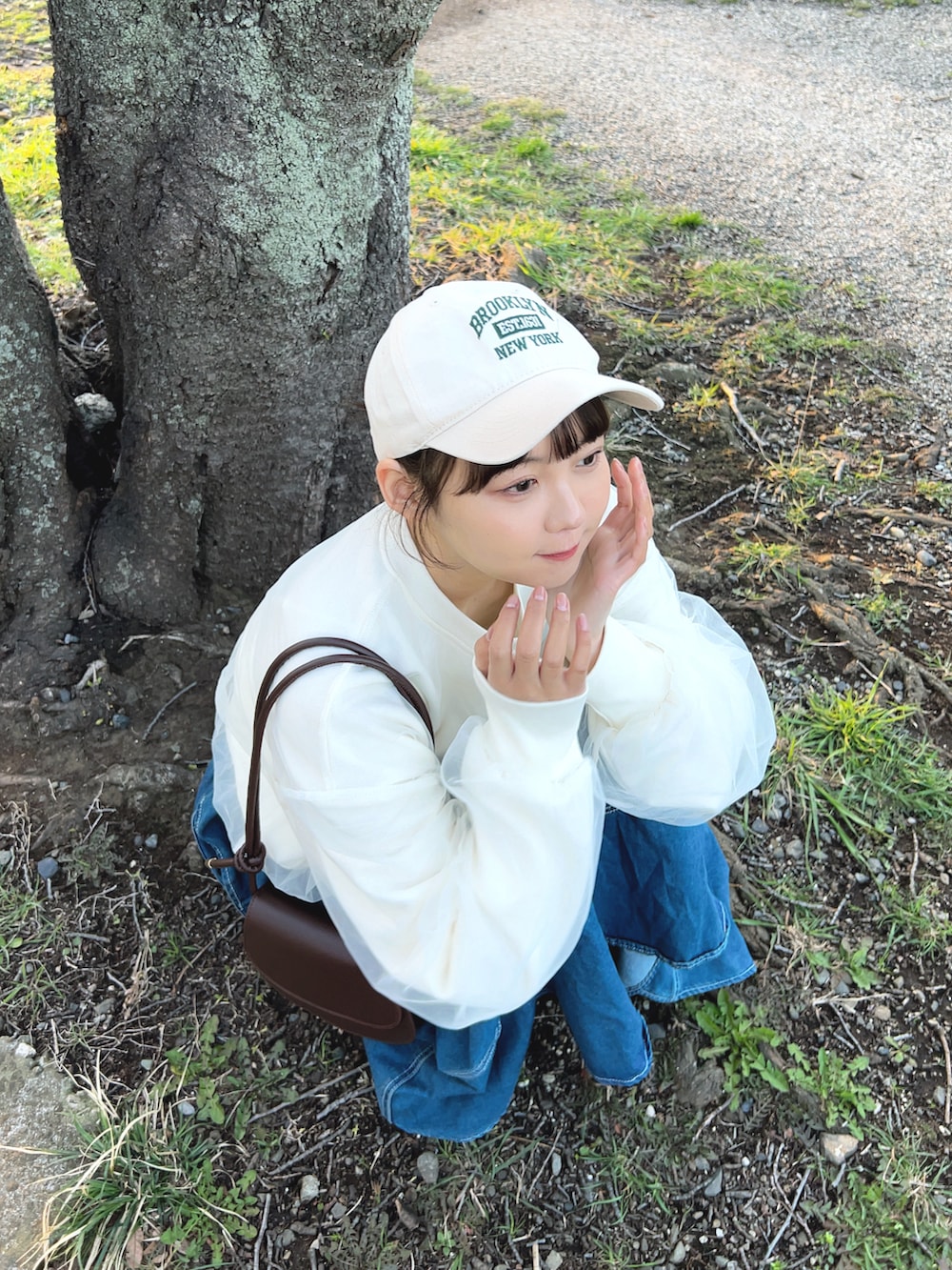 ホワイト系のスウェット、ブルー系のデニムスカート、ホワイト系のスニーカーを着用したレディースの春コーディネートの4枚目の写真