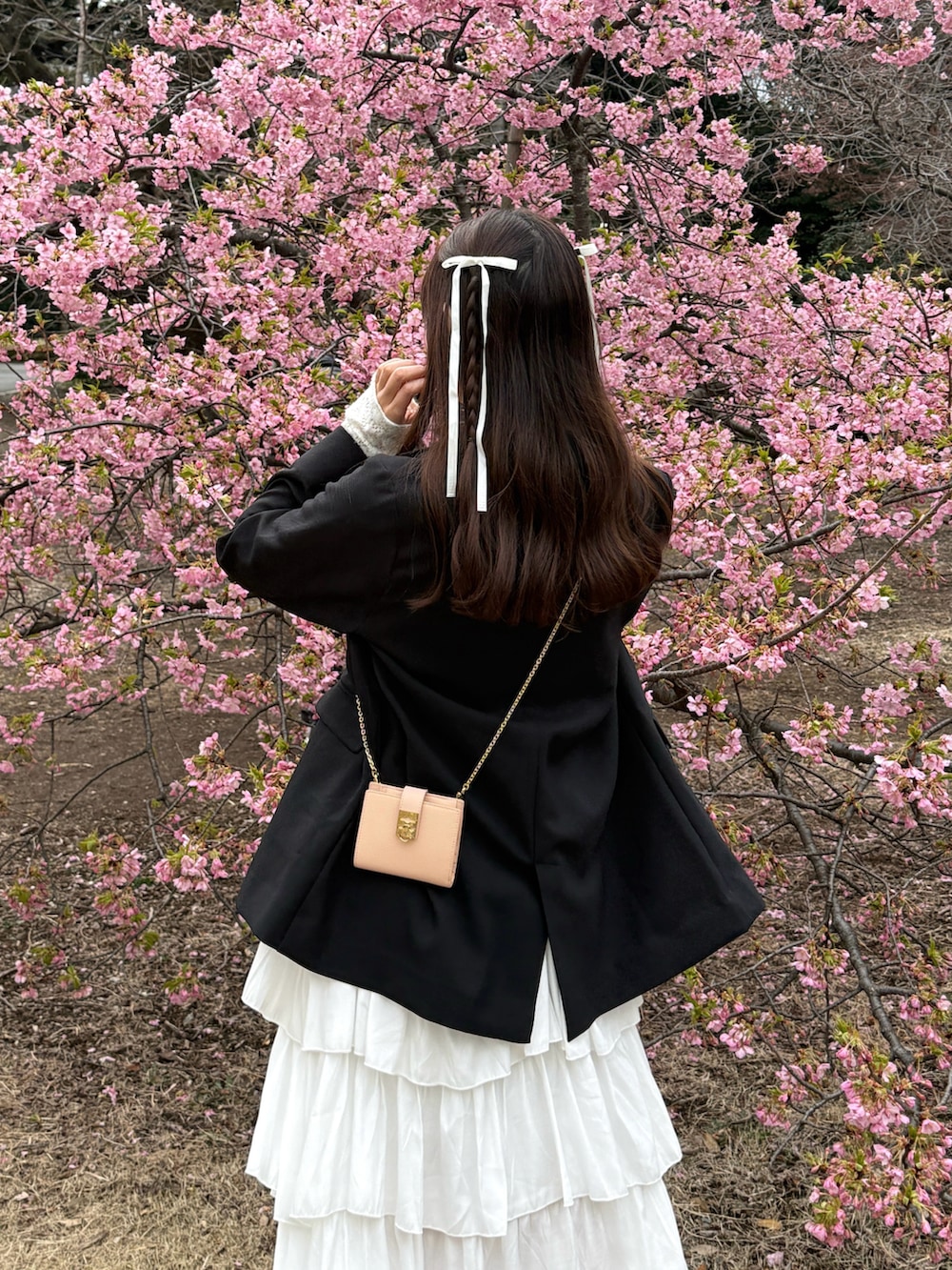 ブラック系のノーカラージャケット、ホワイト系のスカート、ホワイト系のTシャツ/カットソーを着用したレディースの春コーディネートの4枚目の写真