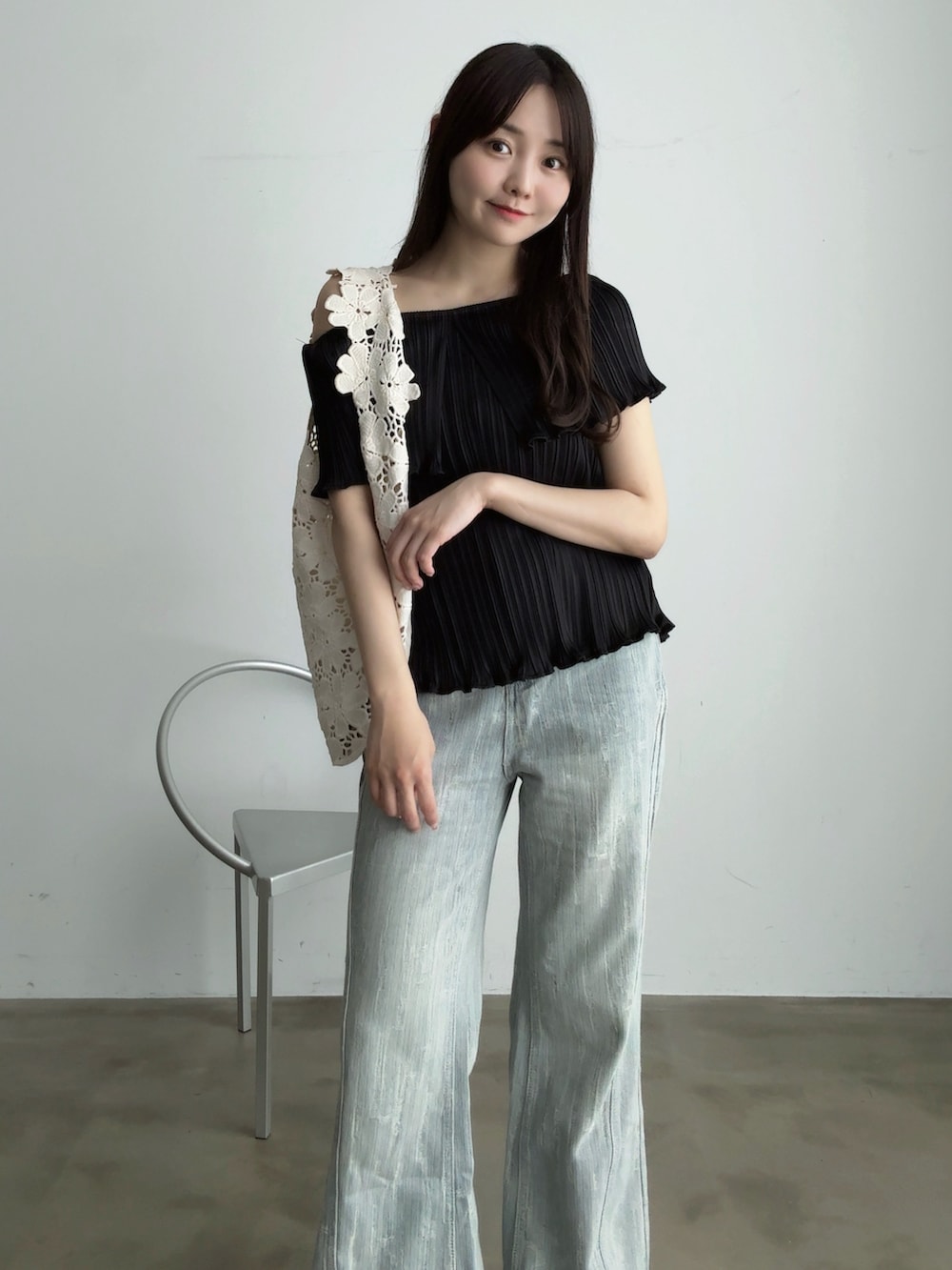 ブルー系のデニムパンツ、ホワイト系のサンダル、ブラック系のシャツ/ブラウスを着用したレディースの夏コーディネートの3枚目の写真