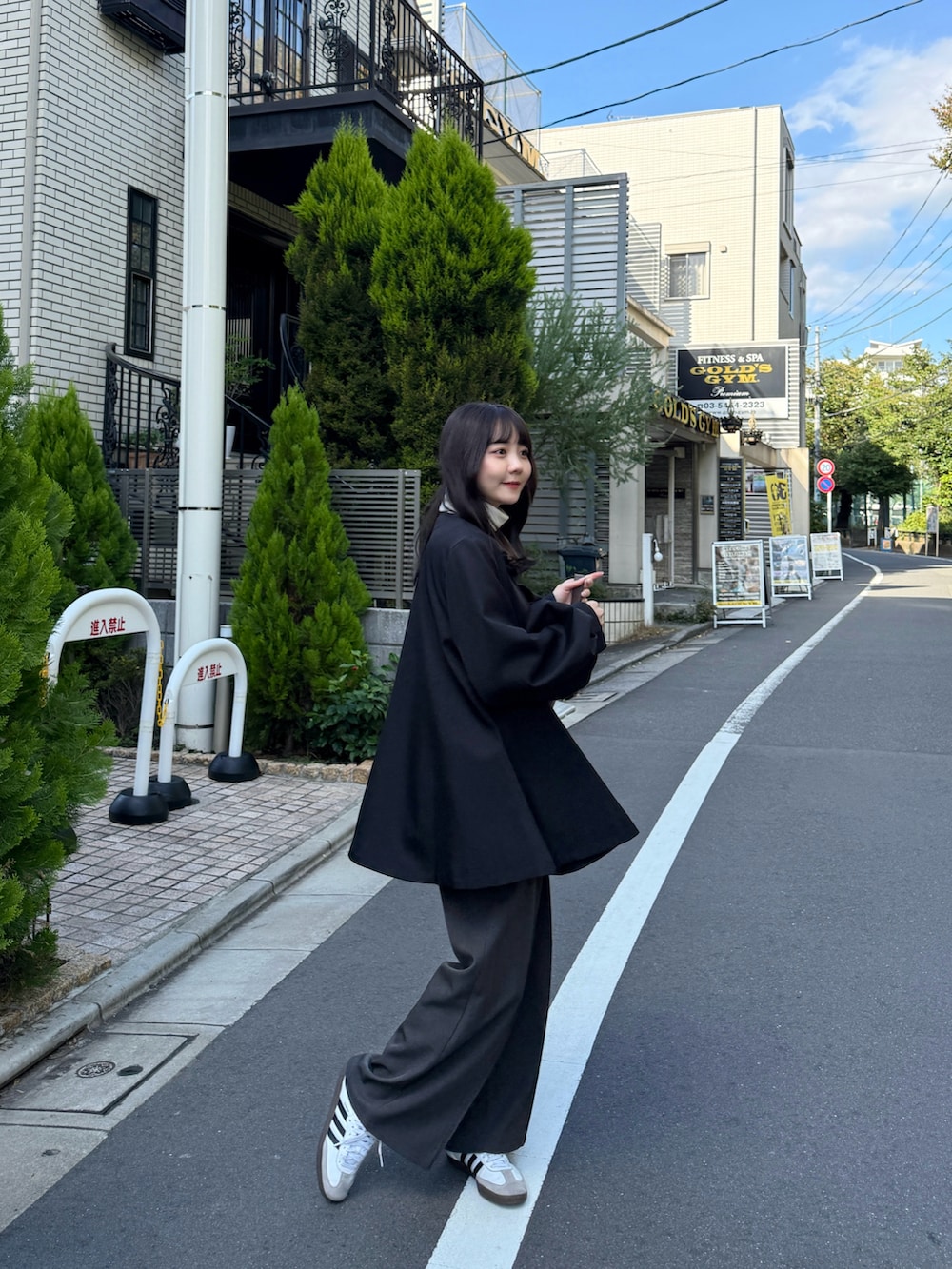 ホワイト系のニット/セーター、ブラック系のノーカラージャケット、グレー系のスラックスを着用したレディースの秋コーディネートの2枚目の写真