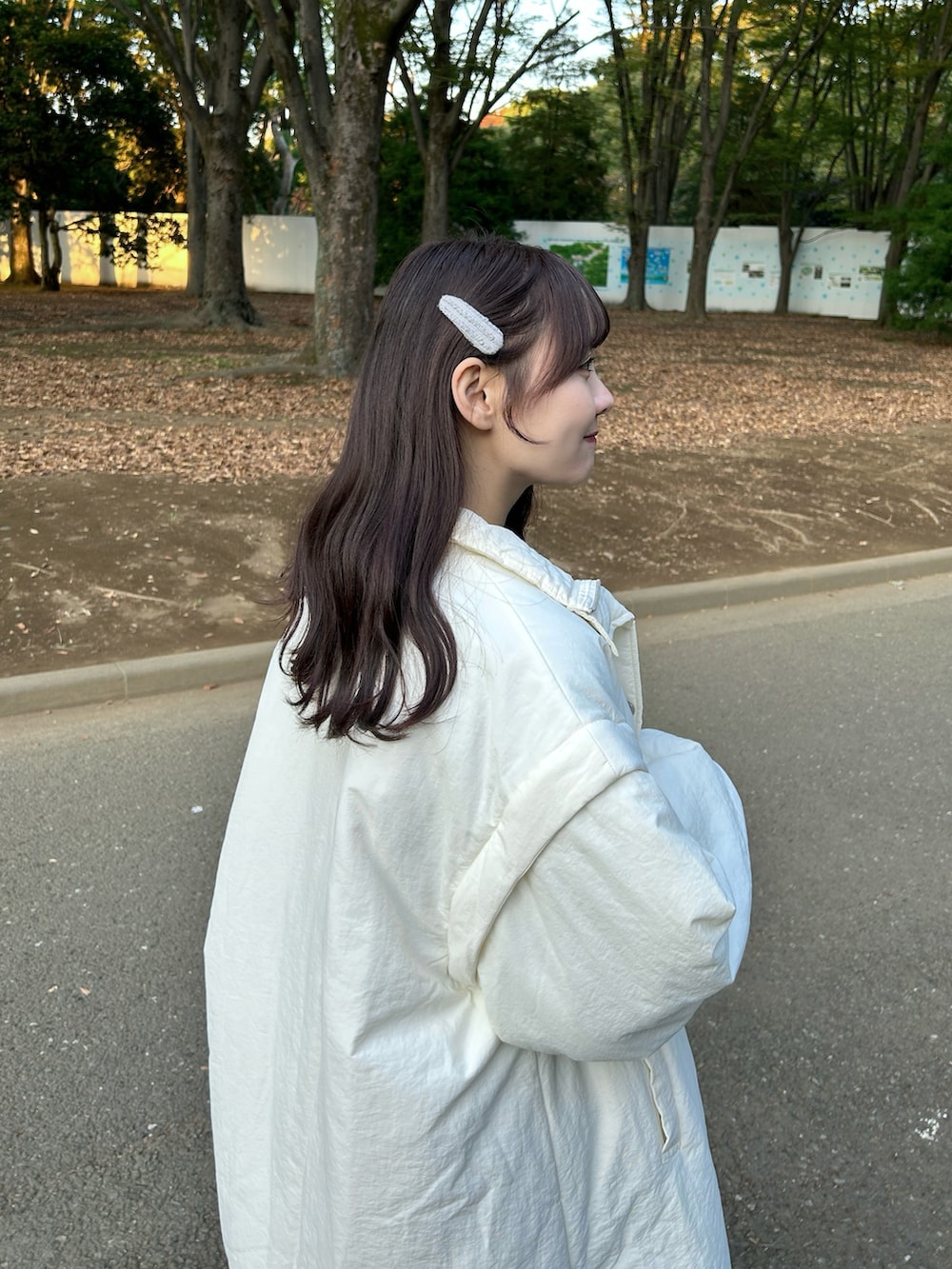 ホワイト系のダウンジャケット/コート、ブルー系のスウェット、ホワイト系のバッグを着用したレディースの冬コーディネートの4枚目の写真