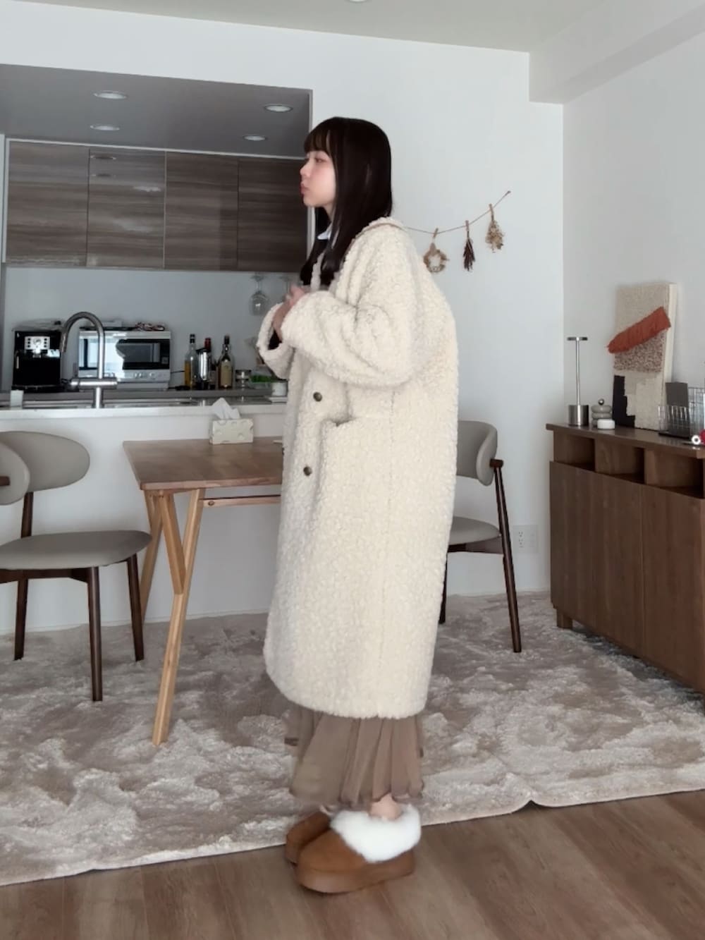 ブラウン系のブーツ、ベージュ系のその他アウター、ブラウン系のスカートを着用したレディースの冬コーディネートの4枚目の写真