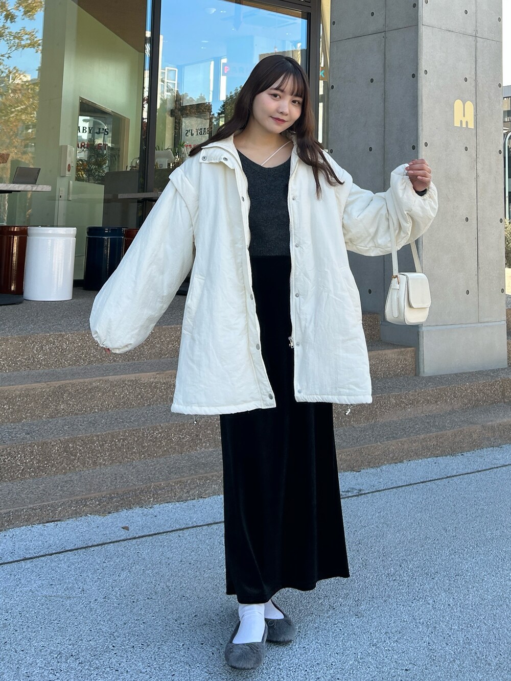 ホワイト系のキャミソール、グレー系のニット/セーター、ホワイト系のダウンジャケット/コートを着用したレディースの冬コーディネートの5枚目の写真