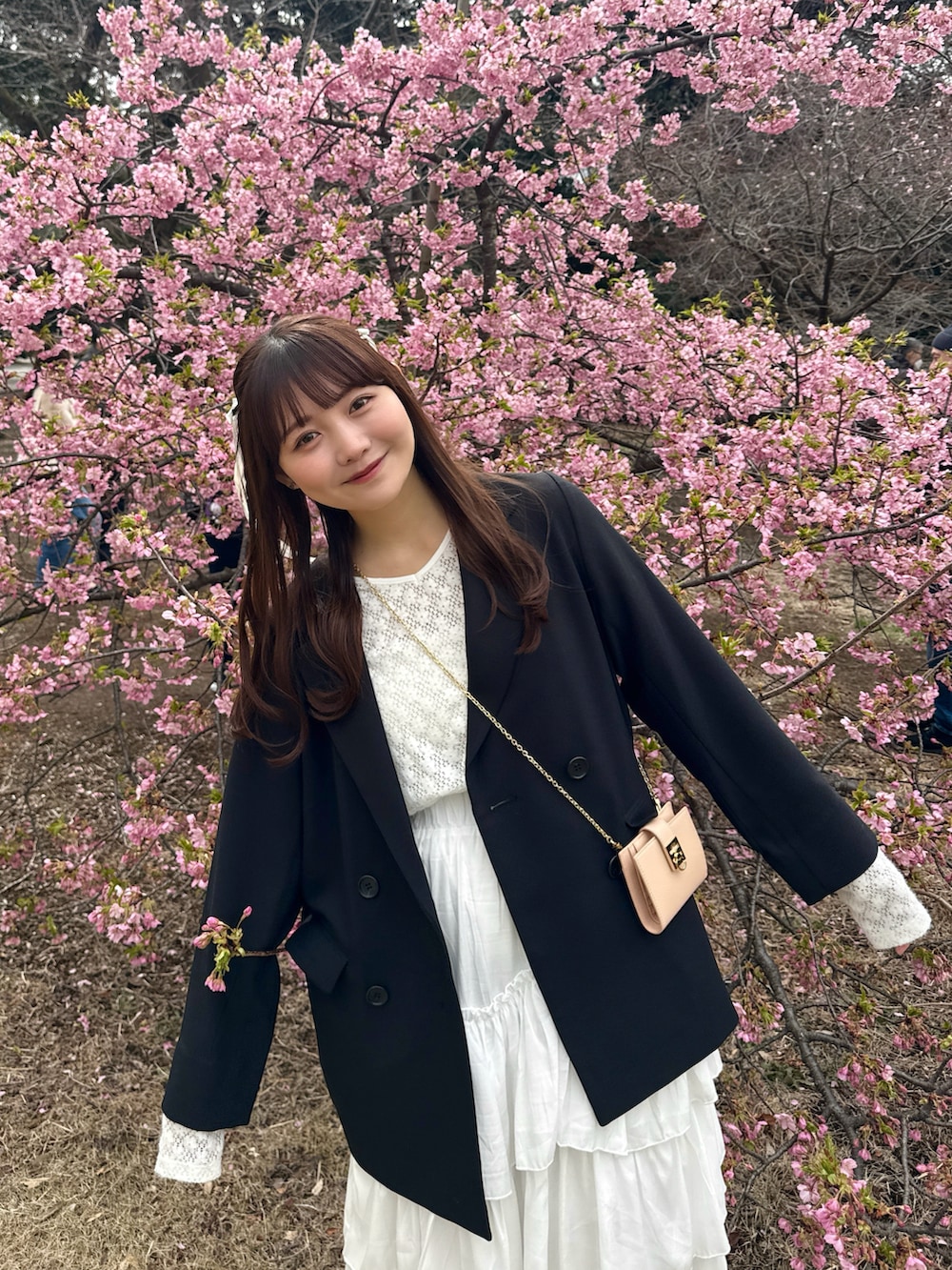 ブラック系のノーカラージャケット、ホワイト系のスカート、ホワイト系のTシャツ/カットソーを着用したレディースの春コーディネートの3枚目の写真