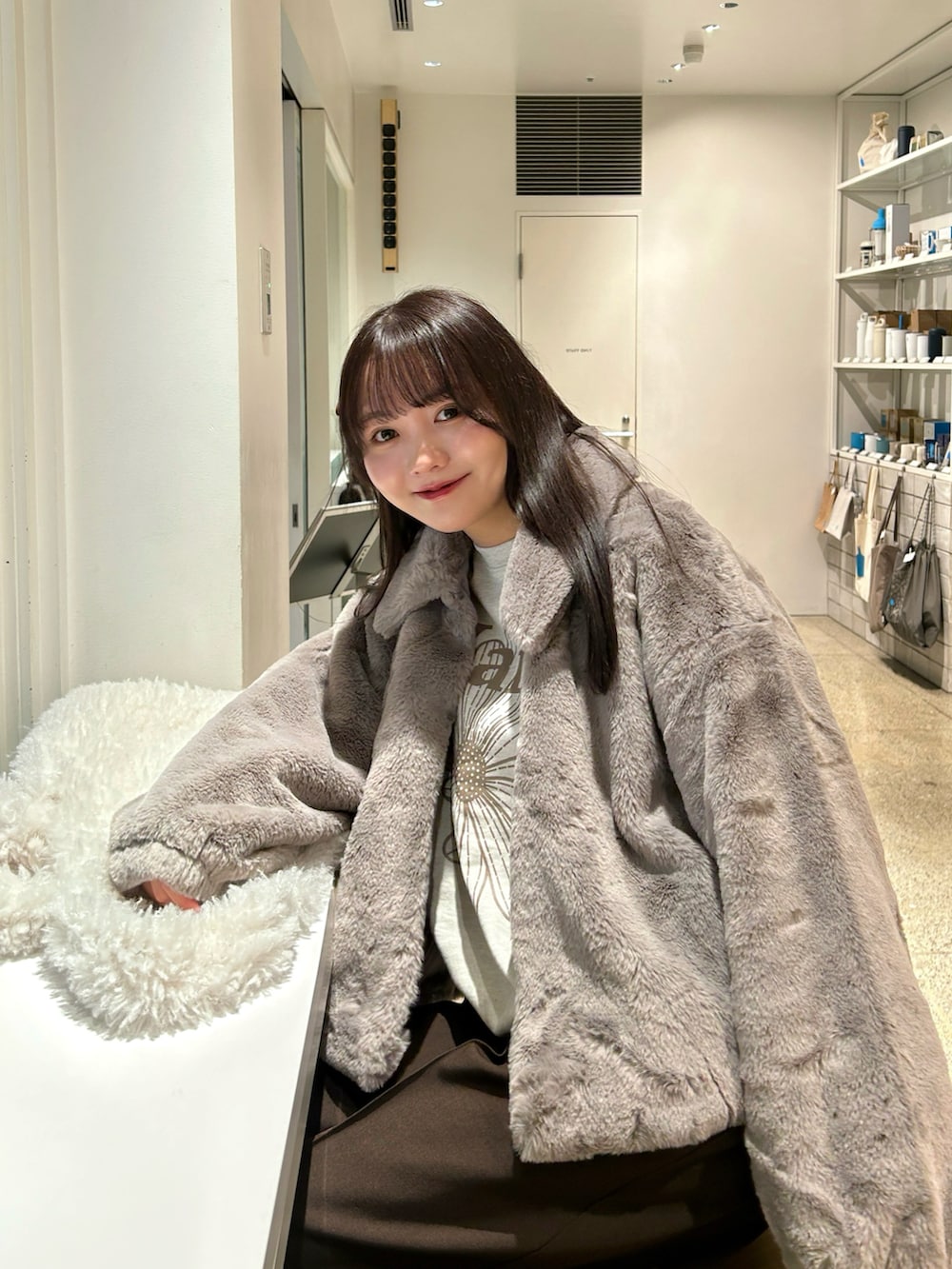 ベージュ系のその他アウター、ブラウン系のスラックス、ブラック系のブーツを着用したレディースの冬コーディネートの3枚目の写真