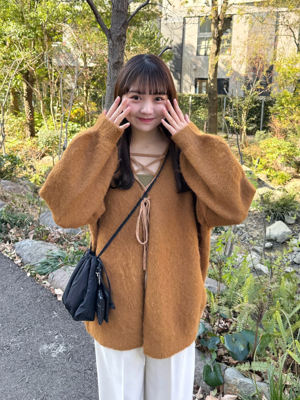 イエロー系のカーディガン/ボレロ、ベージュ系のその他パンツ、ブラック系のスニーカーを着用したレディースの冬コーディネートの2枚目の写真