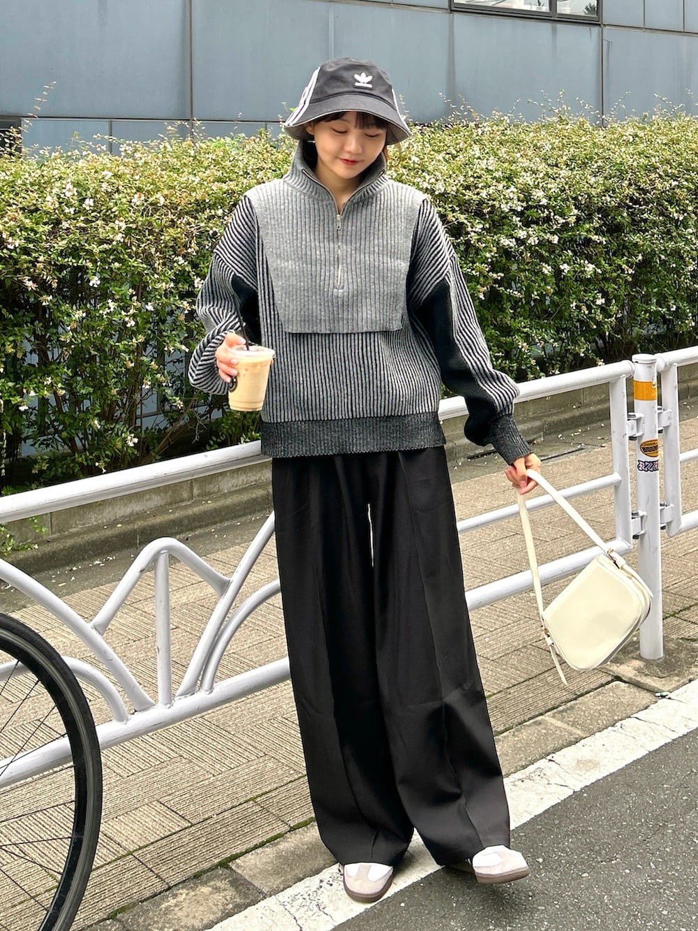 ブラック系のニット/セーター、ブラック系のスラックス、ホワイト系のスニーカーを着用したレディースの秋コーディネートの4枚目の写真