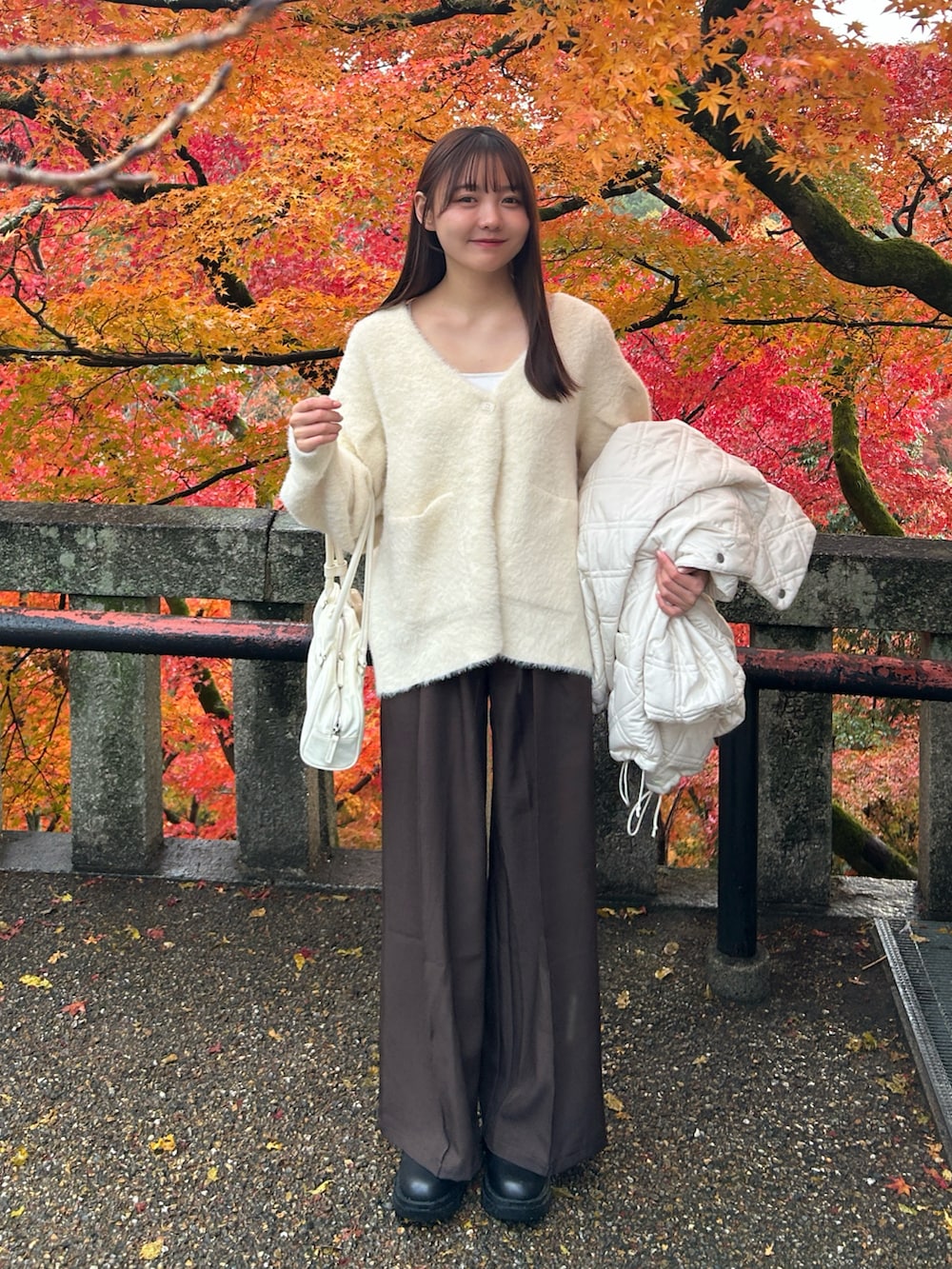 ホワイト系のブルゾン、ホワイト系のカーディガン/ボレロ、ホワイト系のキャミソールを着用したレディースの冬コーディネートの2枚目の写真