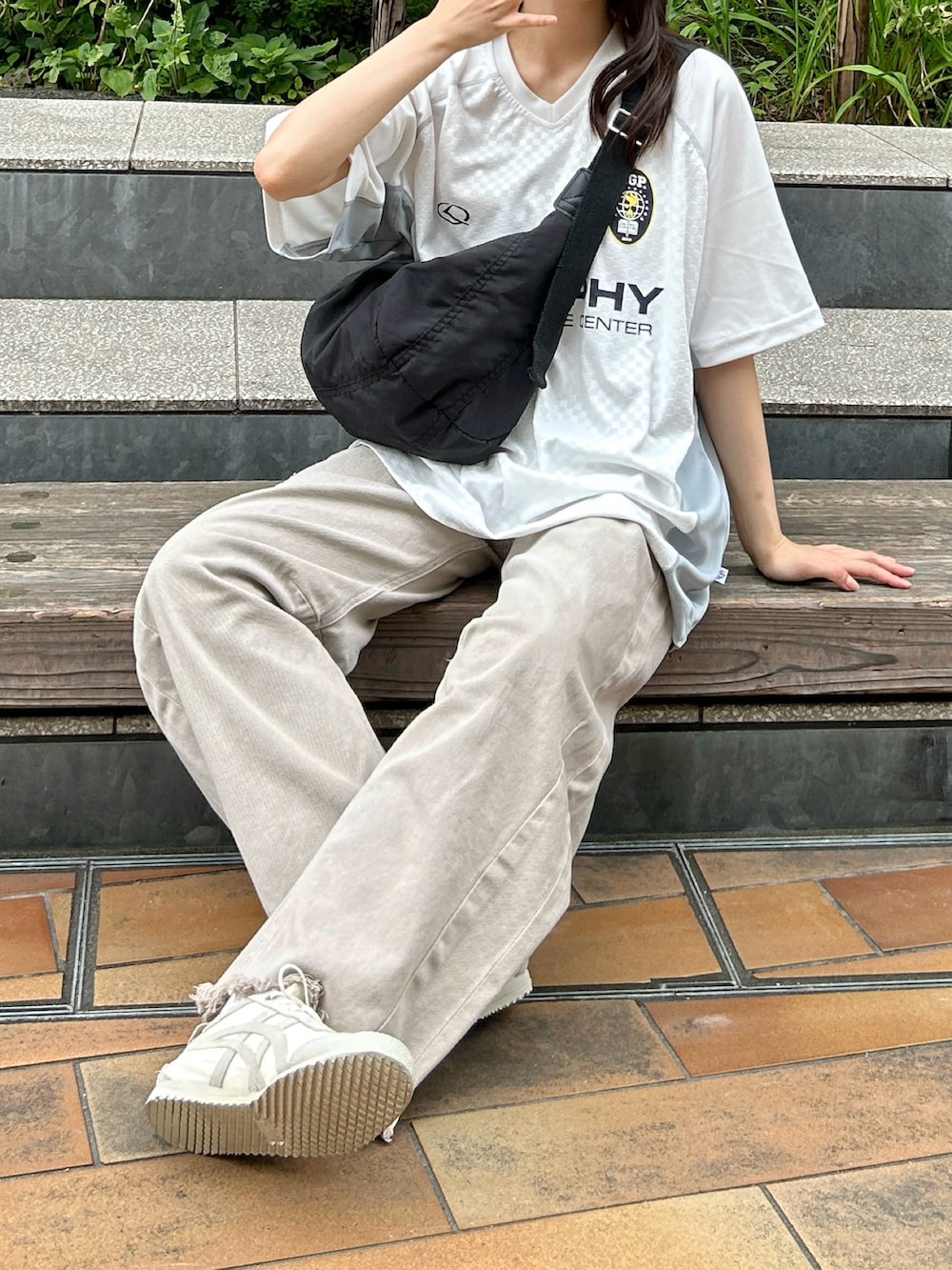 ホワイト系のTシャツ/カットソー、ブラック系のショルダーバッグ、ベージュ系のデニムパンツを着用したレディースの夏コーディネートの4枚目の写真