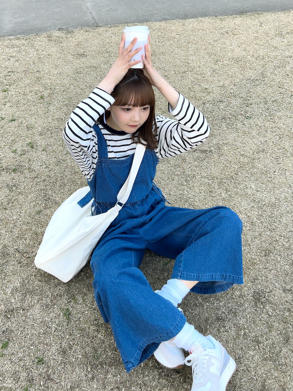 ホワイト系のTシャツ/カットソー、ホワイト系のショルダーバッグ、ブルー系のサロペット/オーバーオールを着用したレディースの春コーディネートの4枚目の写真