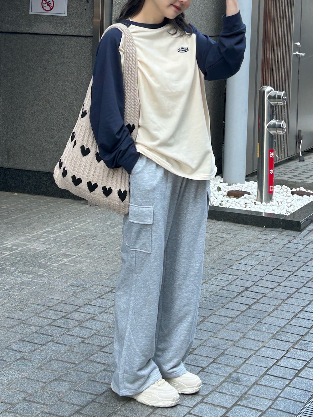 ベージュ系のTシャツ/カットソー、ベージュ系のトートバッグ、ホワイト系のスニーカーを着用したレディースの春コーディネートの2枚目の写真