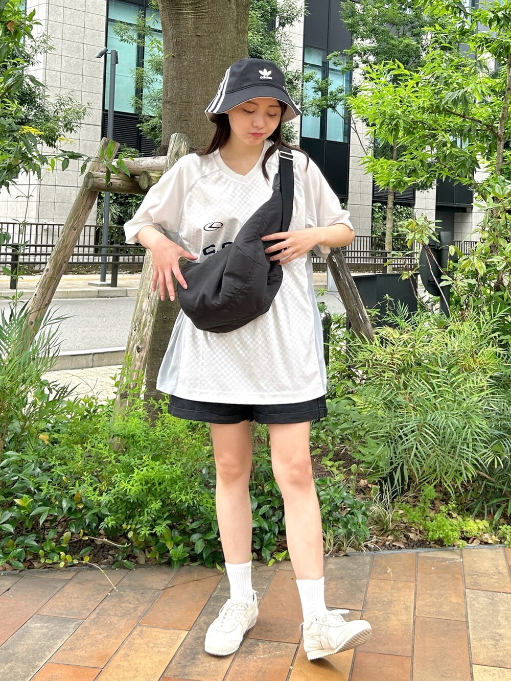 ブラック系のショルダーバッグ、ホワイト系のTシャツ/カットソー、ブラック系のデニムパンツを着用したレディースの夏コーディネートの2枚目の写真