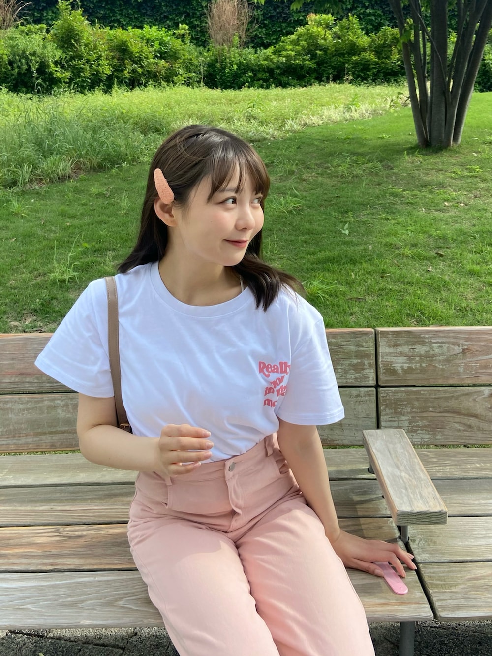 ホワイト系のTシャツ/カットソー、ベージュ系のハンドバッグ、ピンク系のパンツを着用したレディースの夏コーディネートの3枚目の写真