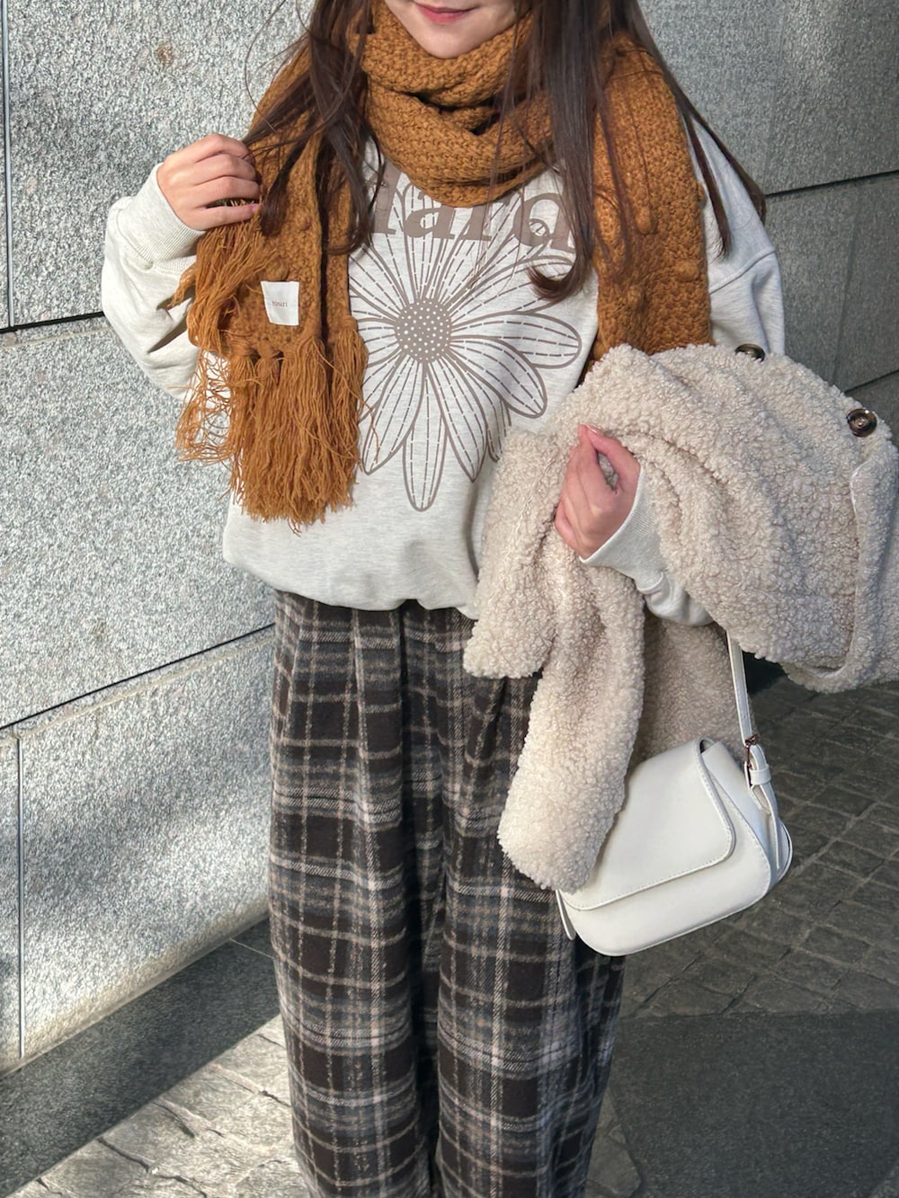 ホワイト系のハンドバッグ、ブラウン系のその他パンツ、ホワイト系のブルゾンを着用したレディースの冬コーディネートの3枚目の写真