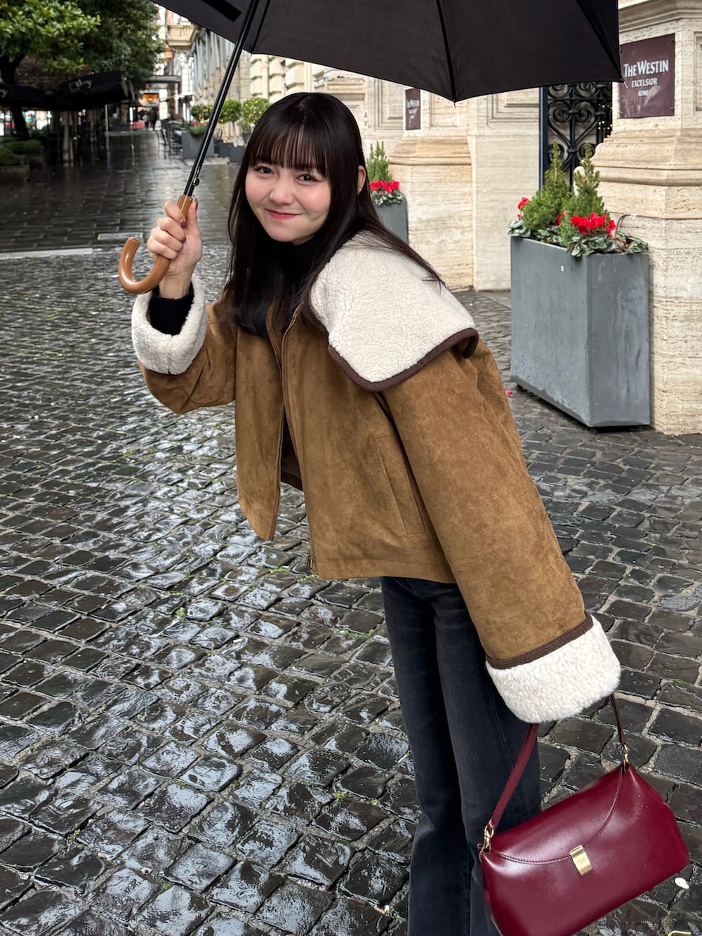 イエロー系のブルゾン、ブラック系のデニムパンツ、レッド系のショルダーバッグを着用したレディースの冬コーディネートの5枚目の写真