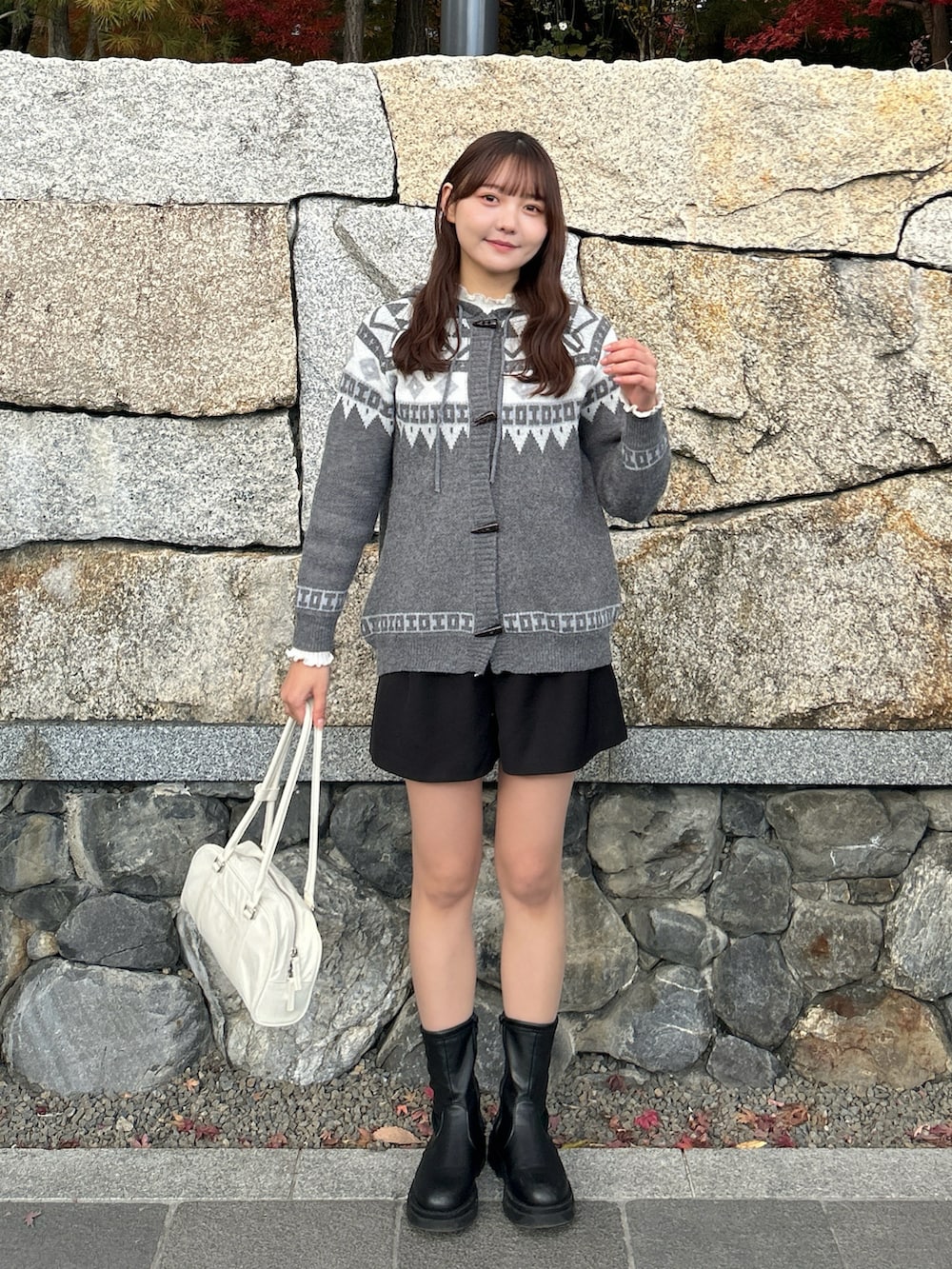 ホワイト系のブルゾン、グレー系のニット/セーター、ホワイト系のTシャツ/カットソーを着用したレディースの冬コーディネートの4枚目の写真