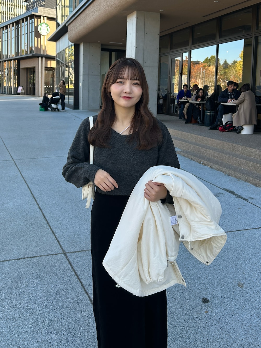 ホワイト系のキャミソール、グレー系のニット/セーター、ホワイト系のダウンジャケット/コートを着用したレディースの冬コーディネートの4枚目の写真