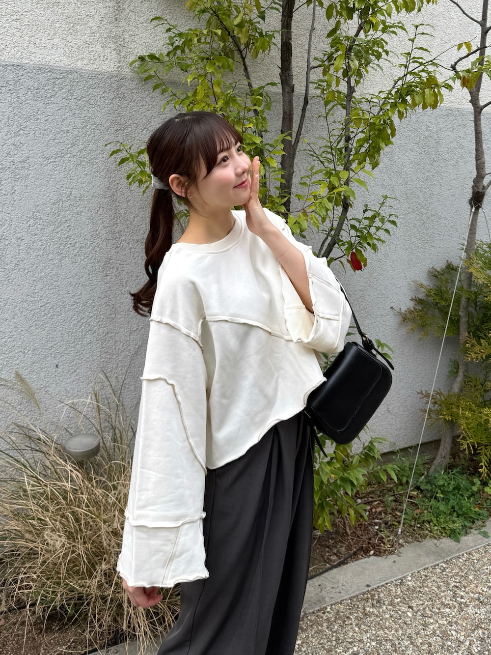 グレー系のスラックス、ホワイト系のスウェット、ベージュ系のテーラードジャケットを着用したレディースの春コーディネートの3枚目の写真