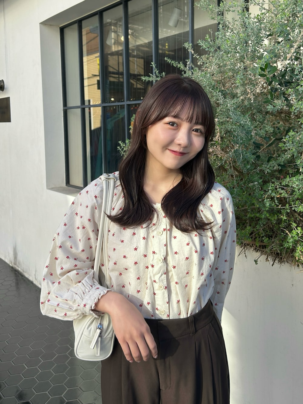 レッド系のシャツ/ブラウス、ホワイト系のバッグ、グレー系のスニーカーを着用したレディースの秋コーディネートの2枚目の写真