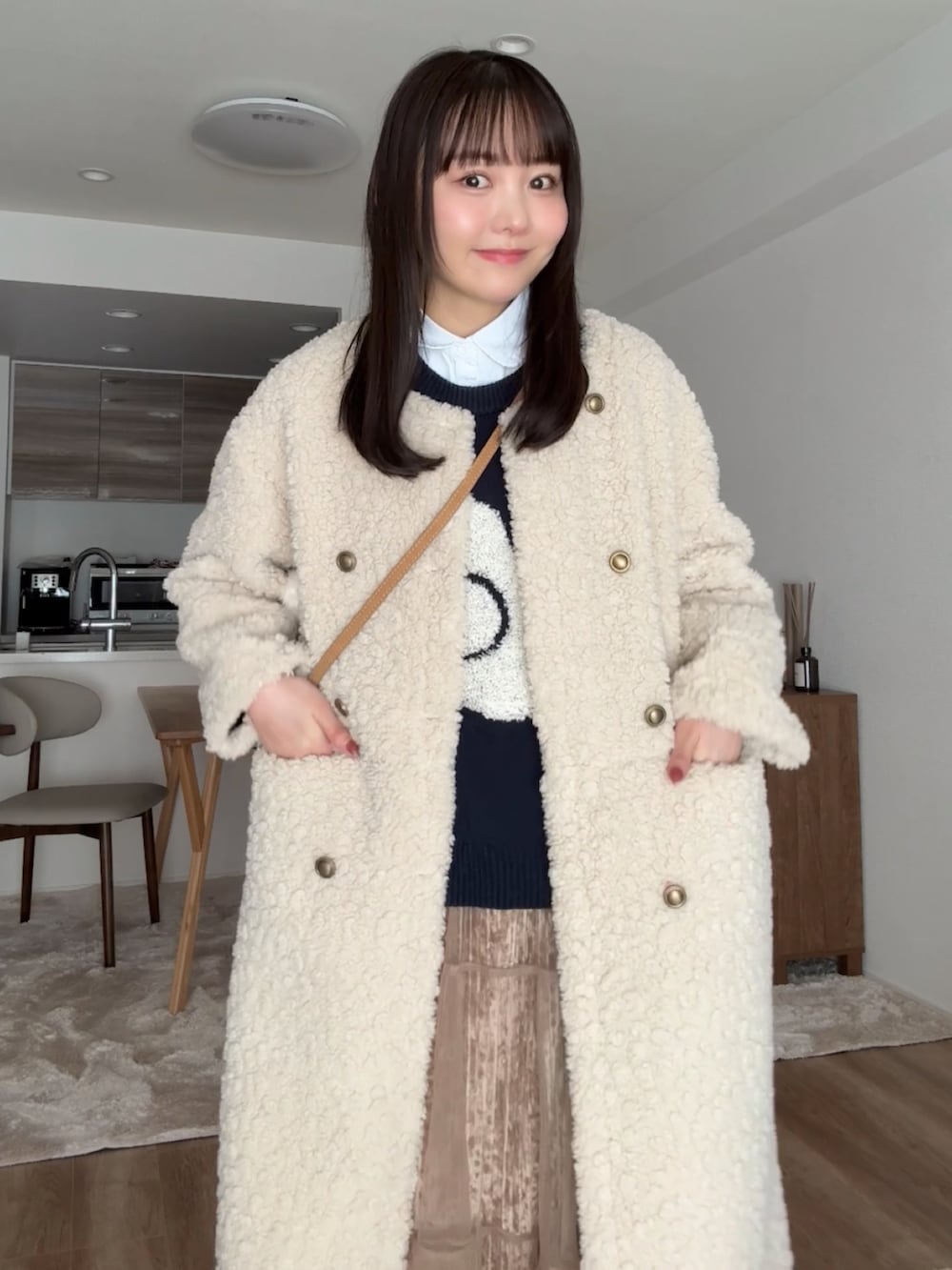 ブラウン系のブーツ、ベージュ系のその他アウター、ブラウン系のスカートを着用したレディースの冬コーディネートの3枚目の写真