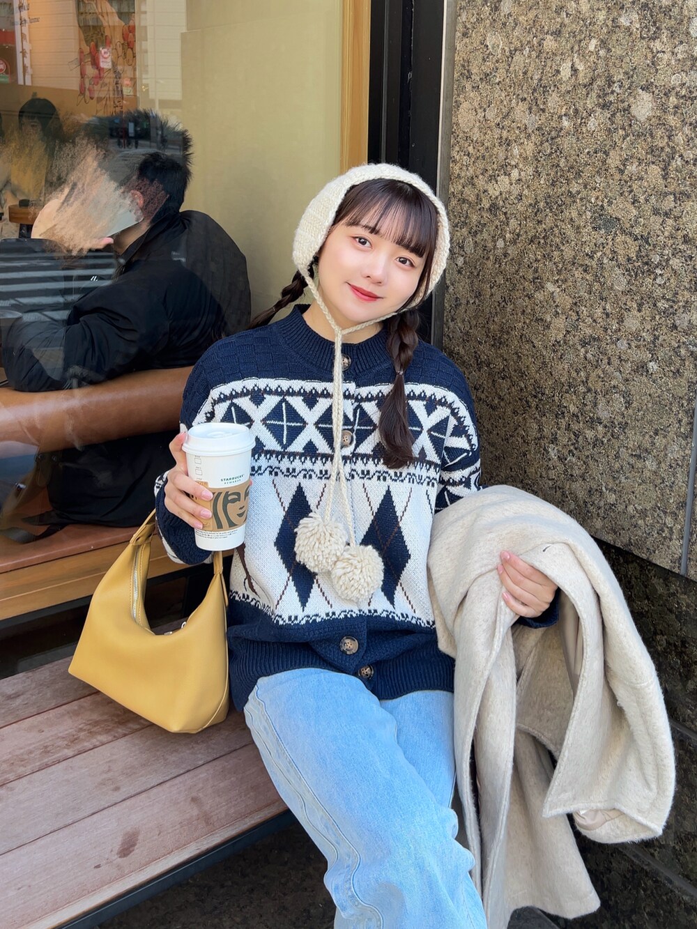 ブルー系のニット/セーター、ブルー系のデニムパンツ、ブラウン系のサンダルを着用したレディースの冬コーディネートの4枚目の写真