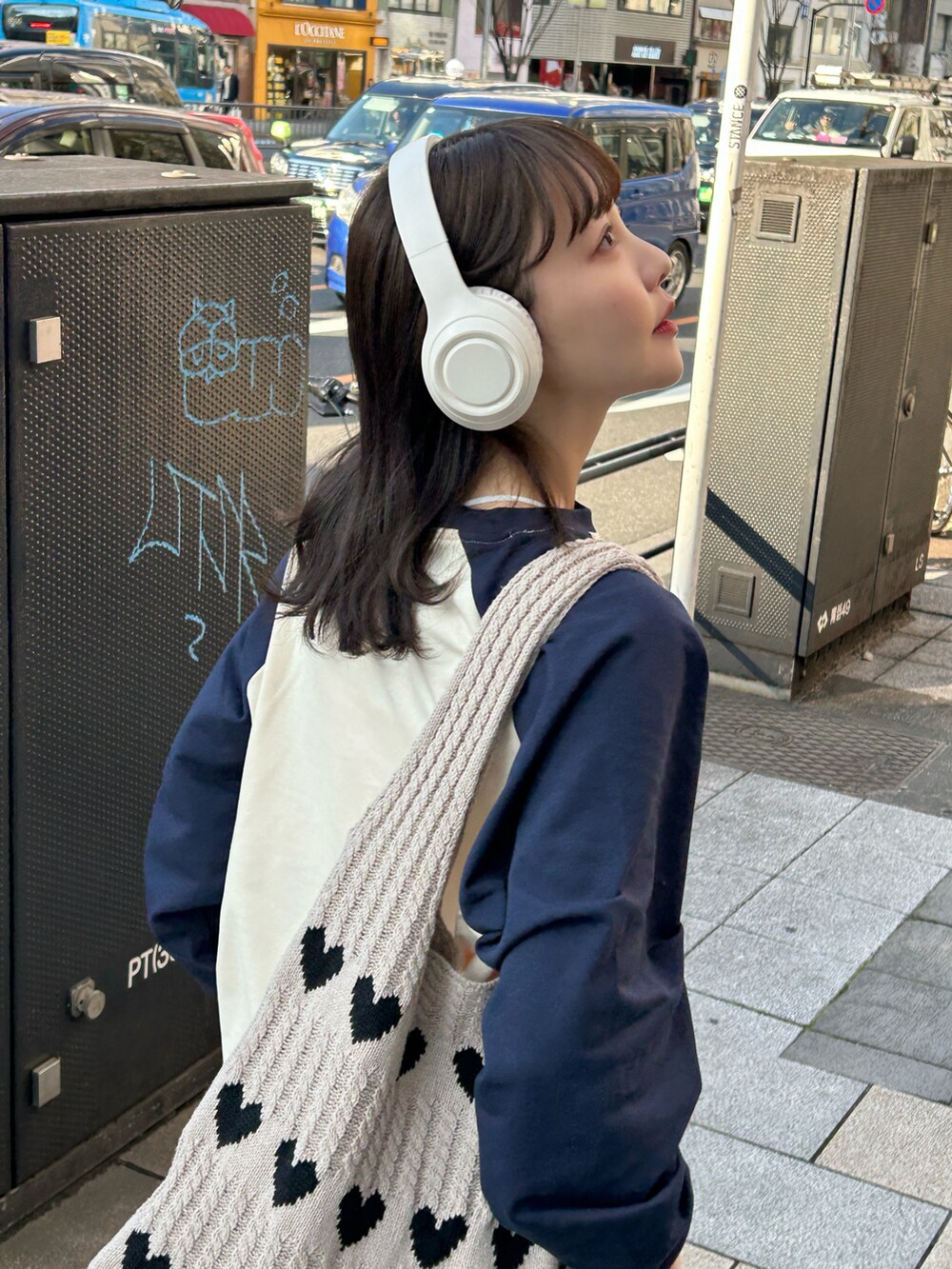 ベージュ系のTシャツ/カットソー、ベージュ系のトートバッグ、ホワイト系のスニーカーを着用したレディースの春コーディネートの4枚目の写真