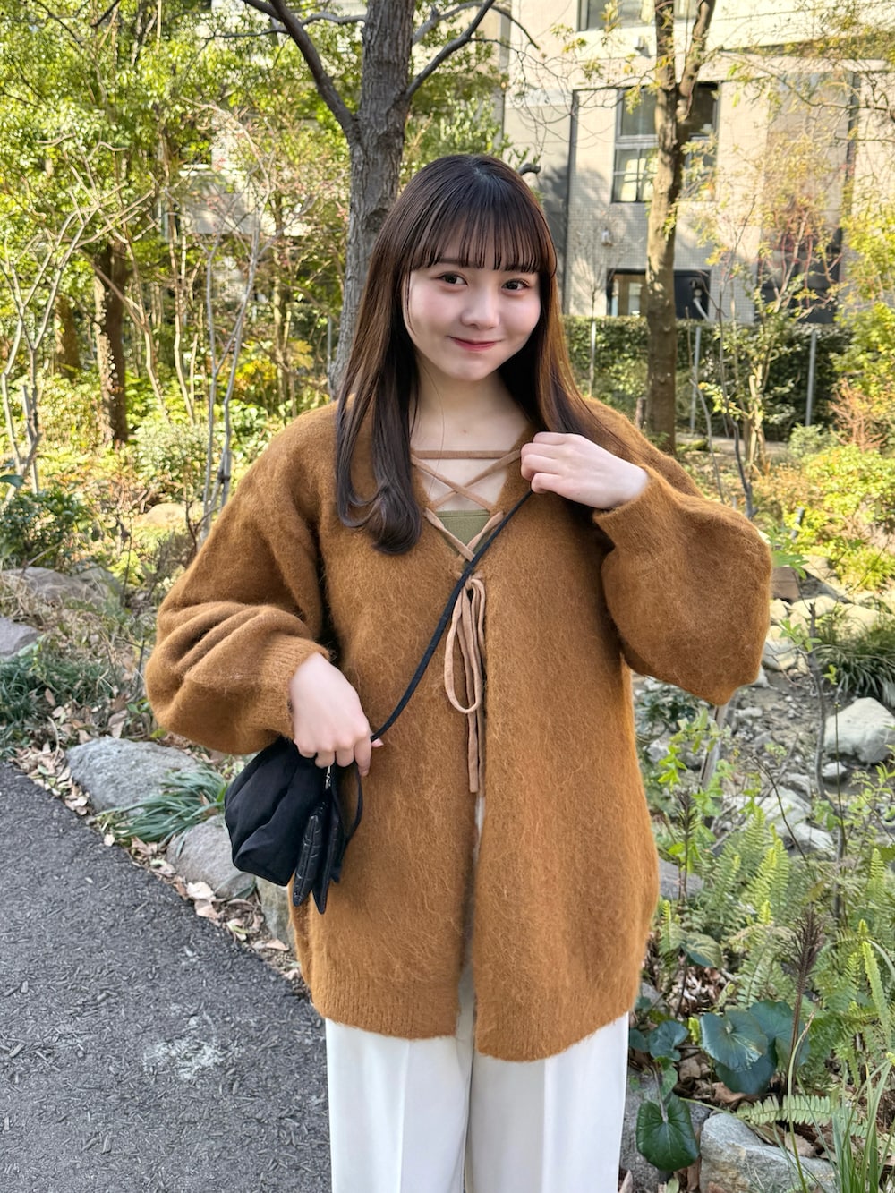 イエロー系のカーディガン/ボレロ、ベージュ系のその他パンツ、ブラック系のスニーカーを着用したレディースの冬コーディネートの5枚目の写真