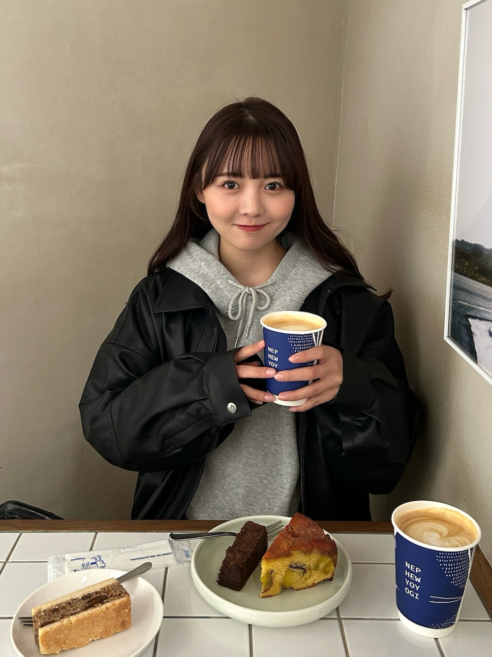 グレー系のパーカー、ブラック系のブルゾン、ブラック系のスカートを着用したレディースの秋コーディネートの5枚目の写真