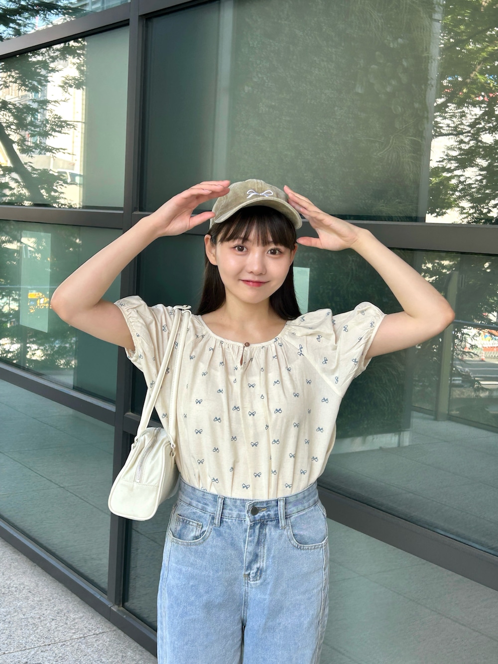 ブルー系のシャツ/ブラウス、ブルー系のデニムパンツ、ホワイト系のバッグを着用したレディースの夏コーディネートの3枚目の写真