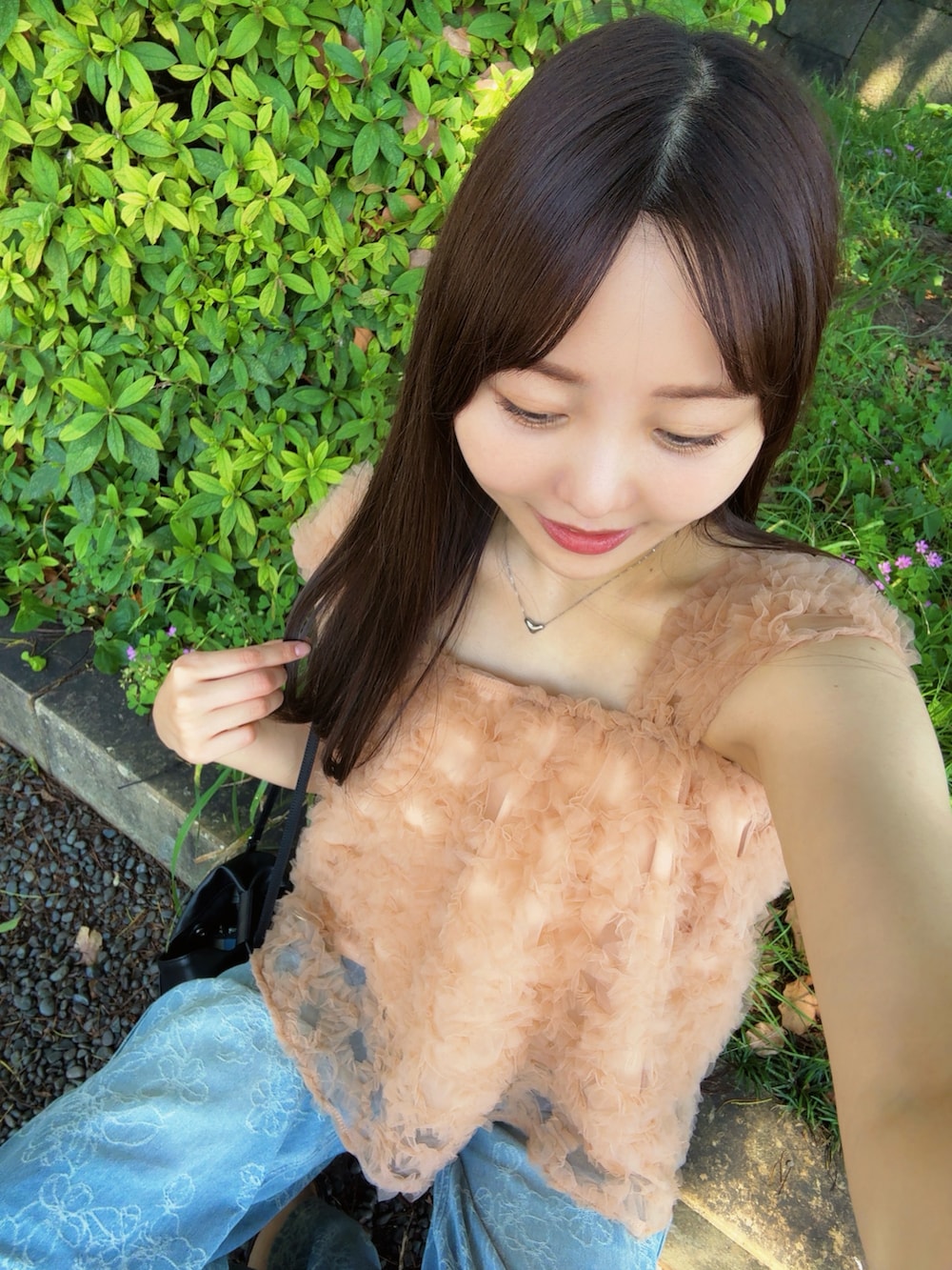 ピンク系のシャツ/ブラウス、ブルー系のデニムパンツ、ブラック系のショルダーバッグを着用したレディースの夏コーディネートの3枚目の写真