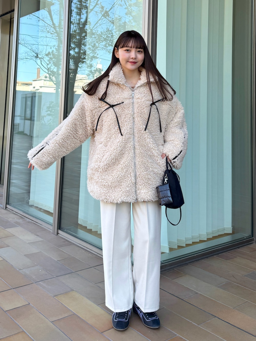 イエロー系のカーディガン/ボレロ、ベージュ系のその他パンツ、ブラック系のスニーカーを着用したレディースの冬コーディネートの4枚目の写真