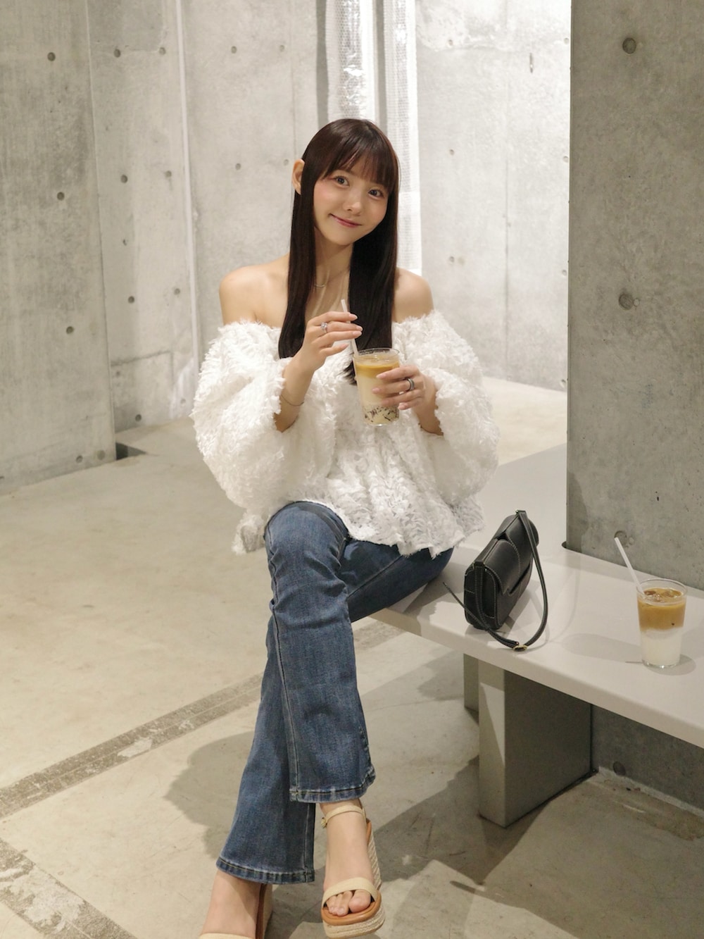 ブルー系のデニムパンツ、ベージュ系のサンダル、ホワイト系のトップスを着用したレディースの夏コーディネートの4枚目の写真