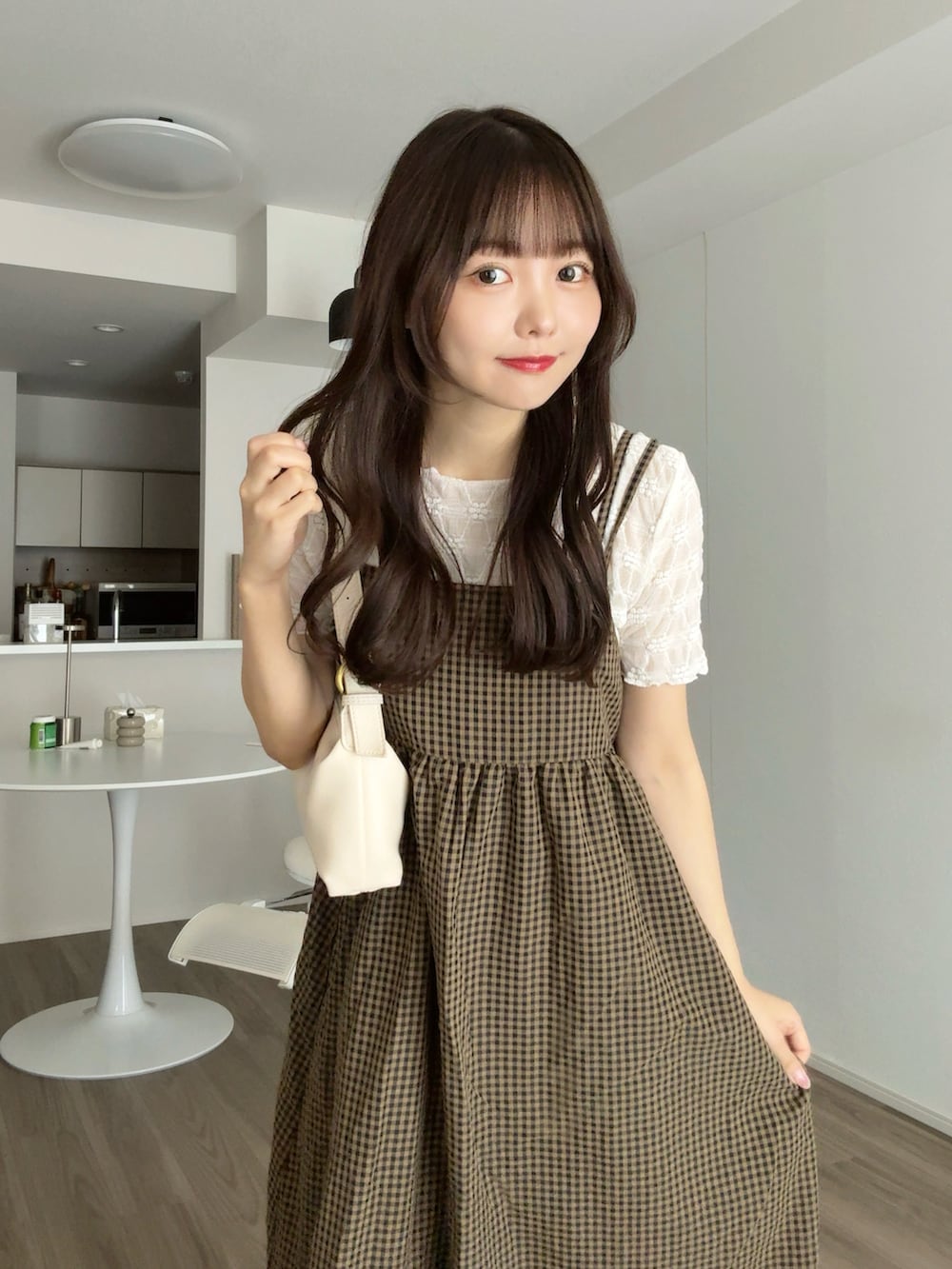 ホワイト系のTシャツ/カットソー、ブラウン系のワンピース、ホワイト系のハンドバッグを着用したレディースの秋コーディネートの2枚目の写真