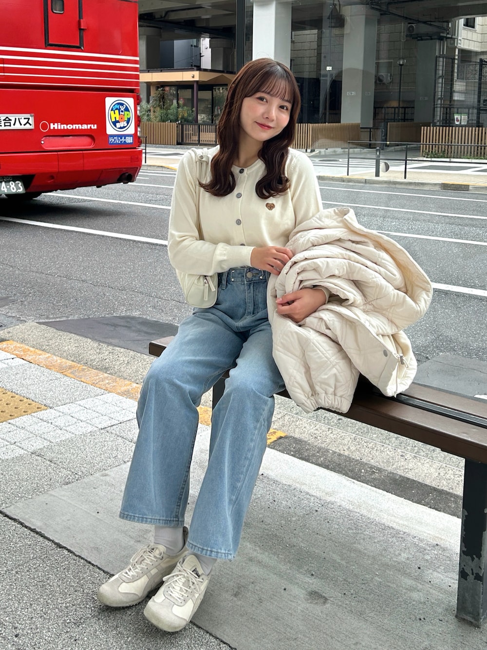 ブルー系のトップス、ブルー系のデニムパンツ、ベージュ系のスニーカーを着用したレディースの秋コーディネートの3枚目の写真