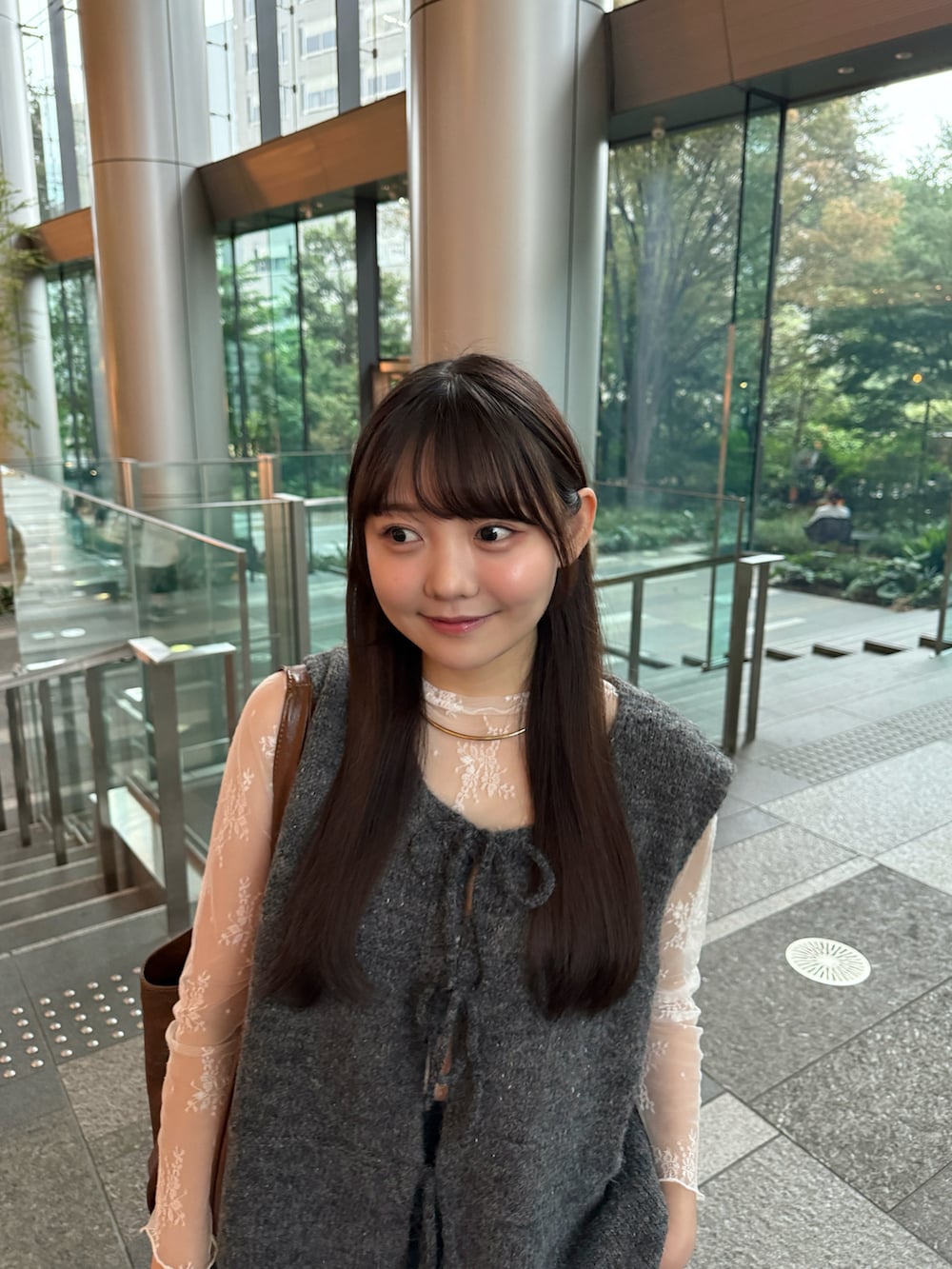 グレー系のベスト、ブラック系のその他パンツ、ホワイト系のスニーカーを着用したレディースの秋コーディネートの2枚目の写真