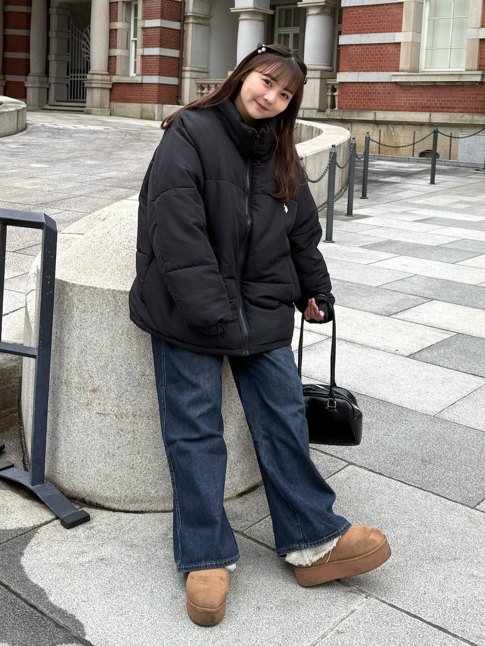 イエロー系のブーツ、ブラック系のダウンジャケット/コート、ブラック系のショルダーバッグを着用したレディースの冬コーディネートの4枚目の写真