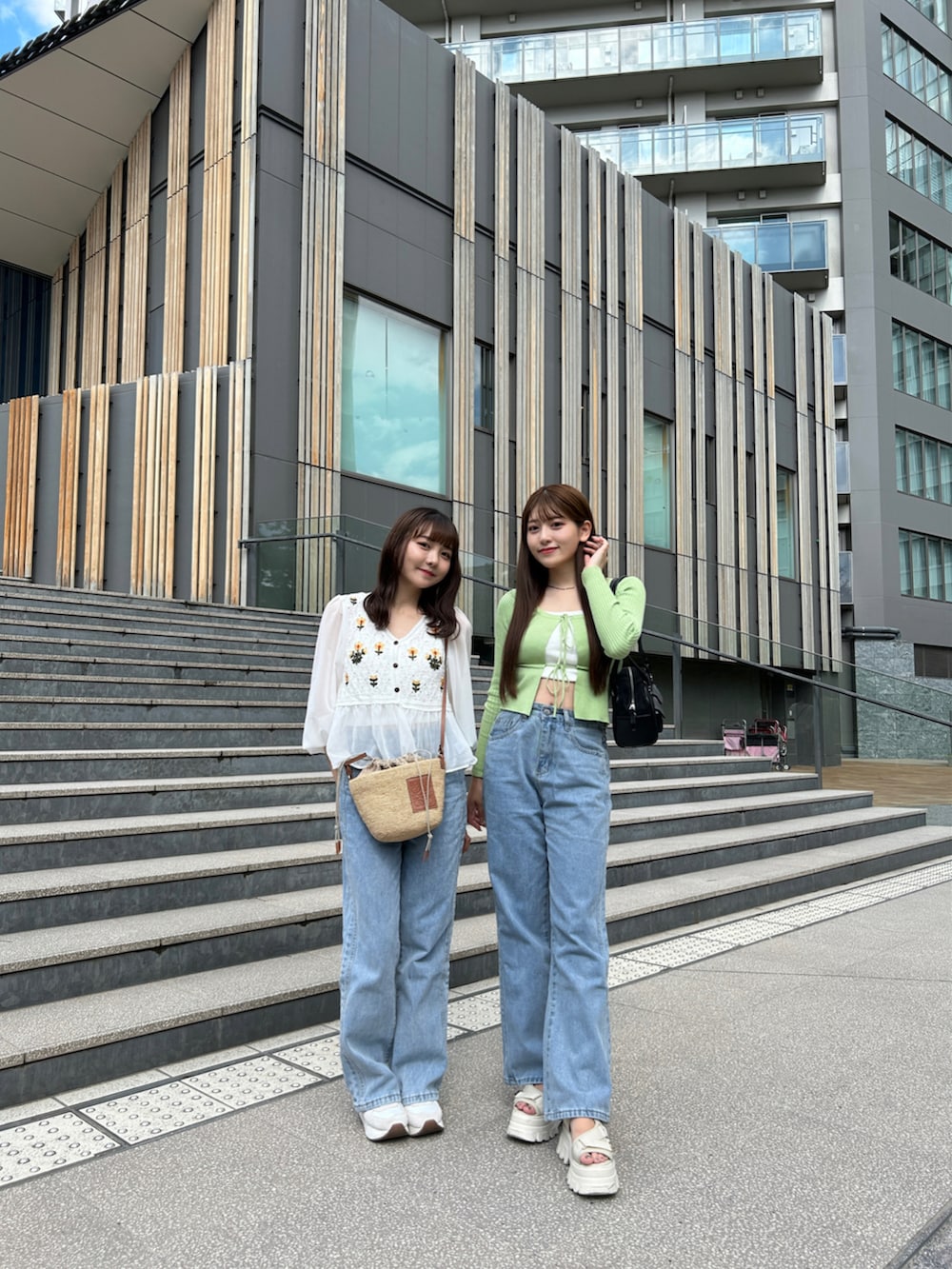 ブルー系のデニムパンツ、グレー系のスニーカー、ベージュ系のかごバッグを着用したレディースの夏コーディネートの4枚目の写真