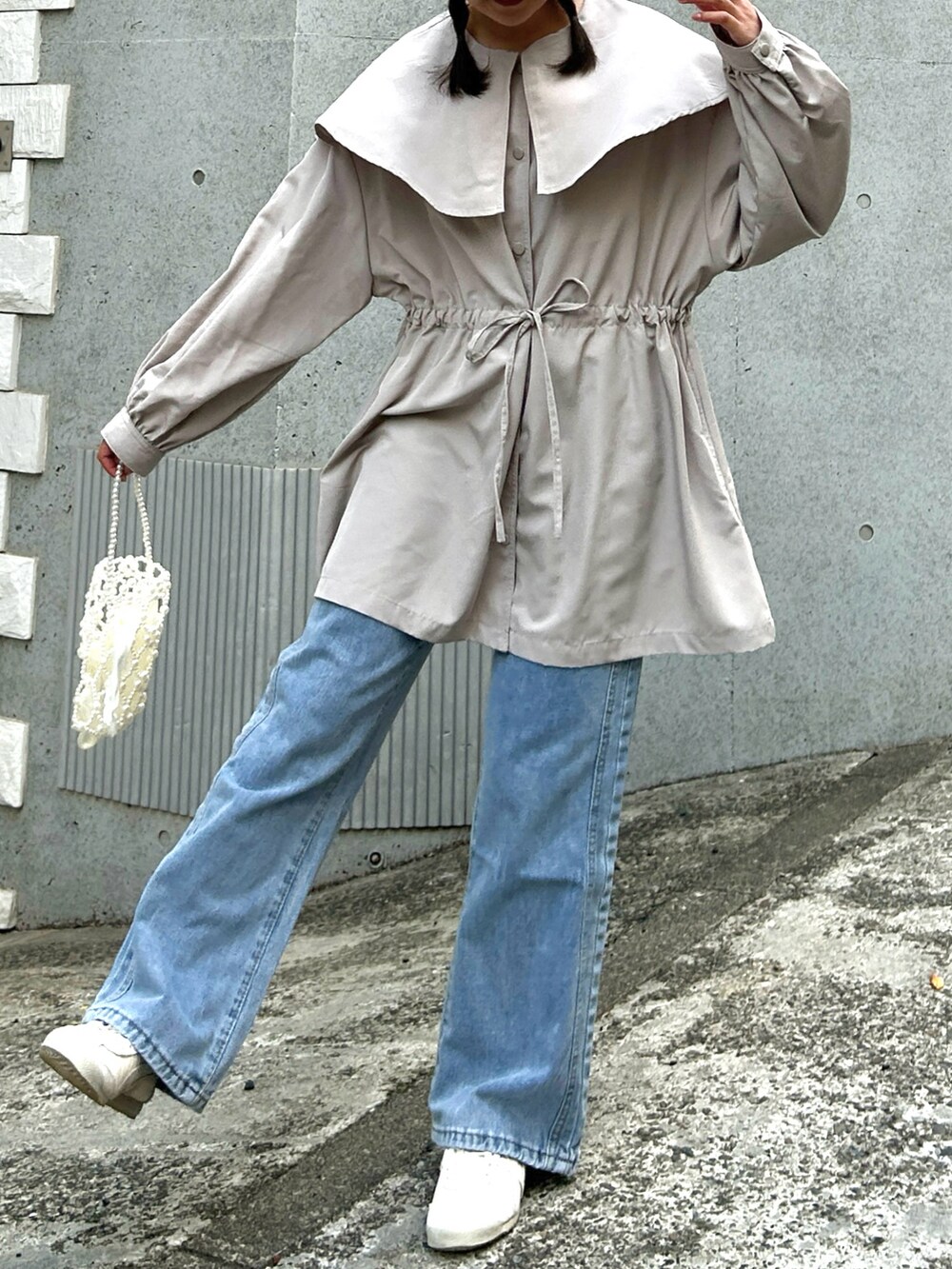 ベージュ系のジャケット/アウター、ブルー系のデニムパンツ、ベージュ系のスニーカーを着用したレディースの春コーディネートの3枚目の写真