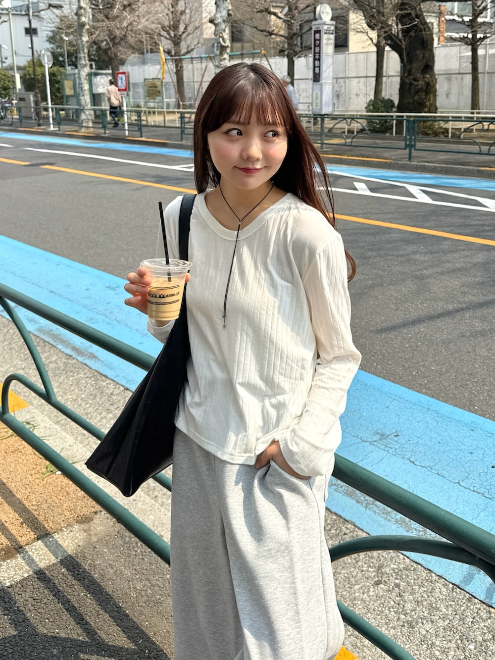 ホワイト系のTシャツ/カットソー、ブラック系のバッグ、グレー系のスウェットパンツを着用したレディースの春コーディネートの2枚目の写真